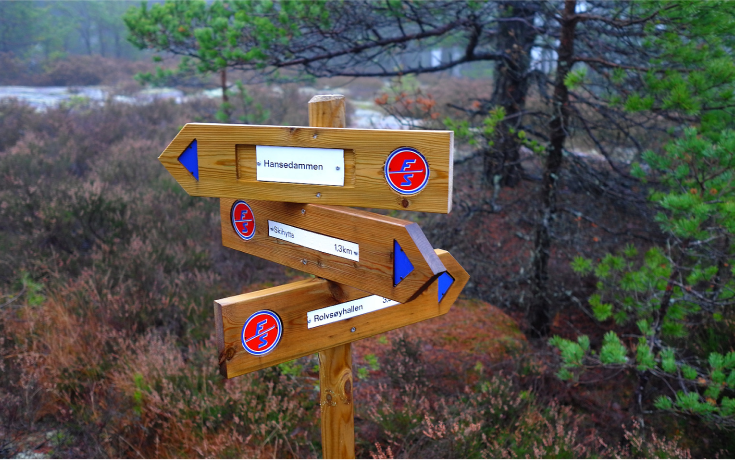 Turskilt plassert i skogen.