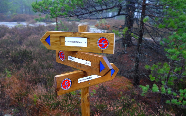 Turskilt plassert i skogen.
