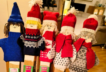 Fem trestolper med strikket genser og lue