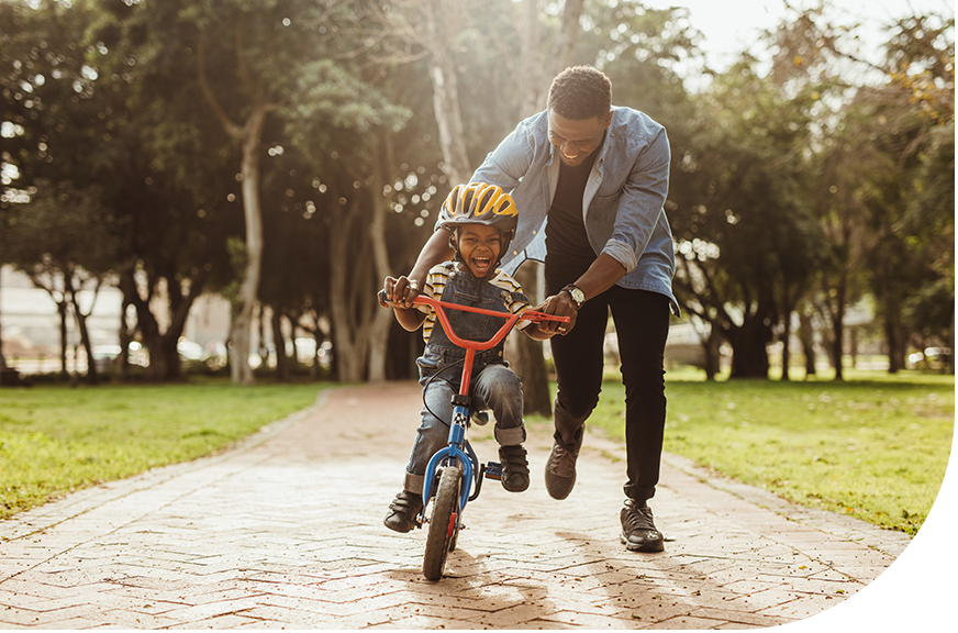 Father teaching son how to ride bike