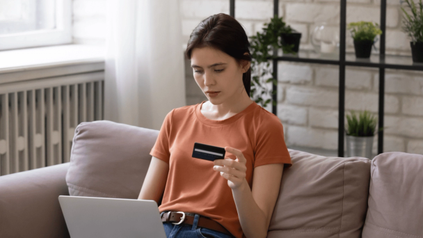 chargebacks Shift4 woman on laptop with credit card in hand