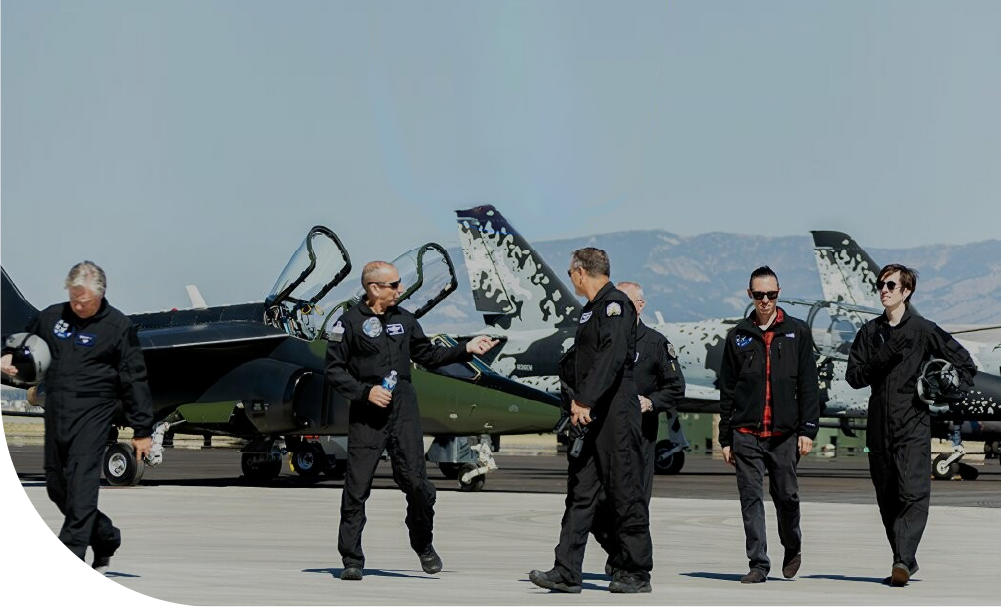 Top Gun Program for Shift4 employees. Once in a lifetime fighter jet experience. Employees pictured walking in front of jets. Shift4 careers.