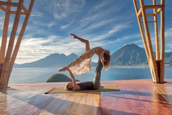 Akro-Yoga-Hebefigur mit Partner, mit „Eagle’s Nest“-Zeichen und Vulkan