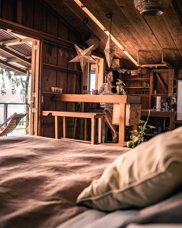 Little Prince suite bedroom with wooden walls, patchwork quilt and warm golden light