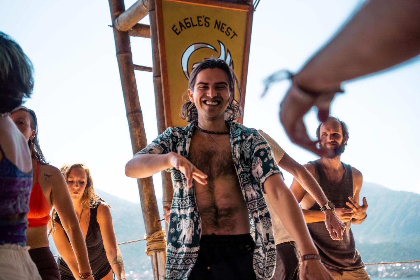 קהל רוקדים אקסטטיים בשקיעה על הבמה ב-Eagle's Nest