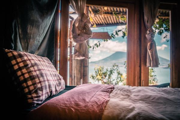 Durch das Fenster des Schlafzimmers in der Hütte aufwachen und den Blick auf den Vulkan genießen