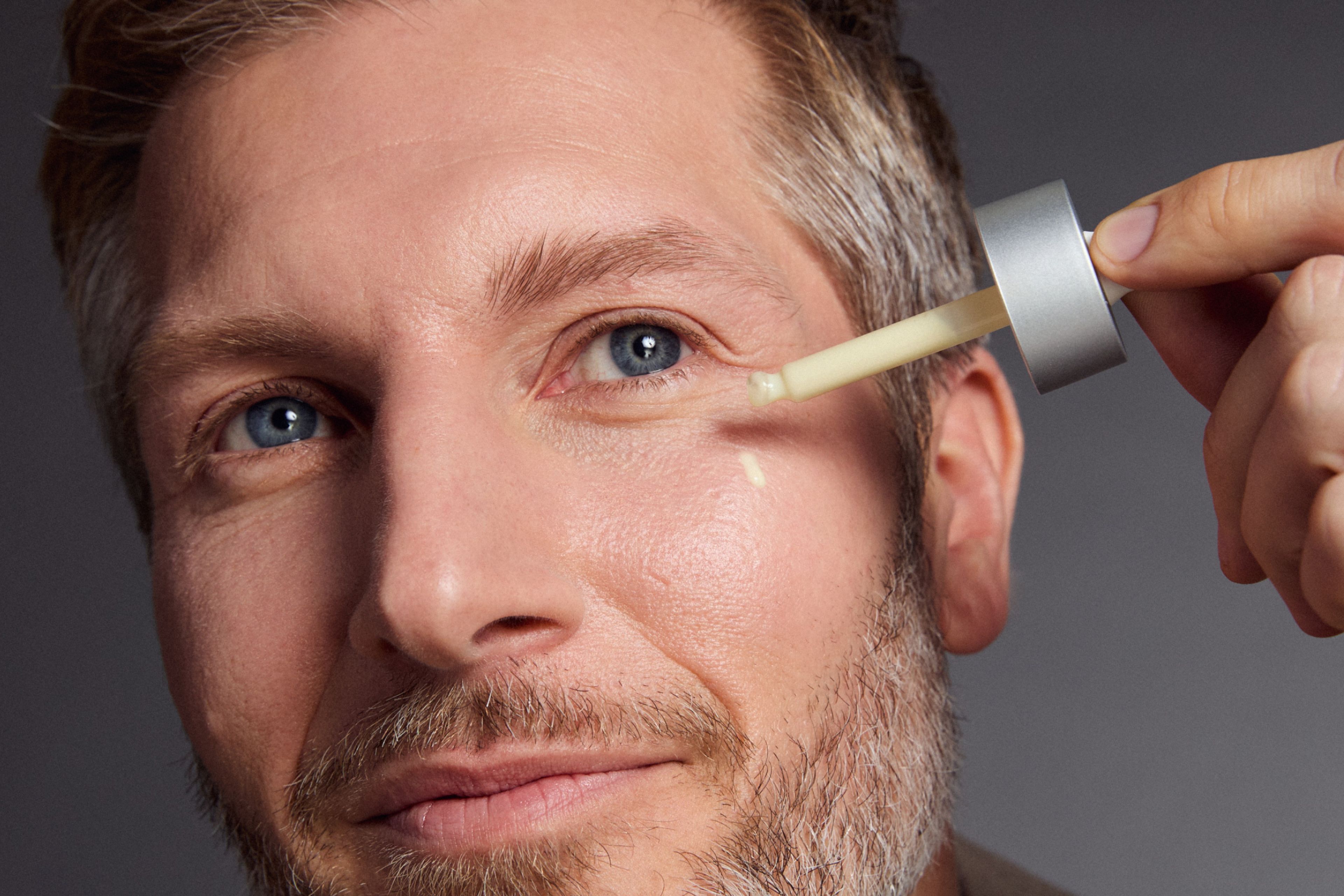 Man applying The Serum by Timeline Skincare