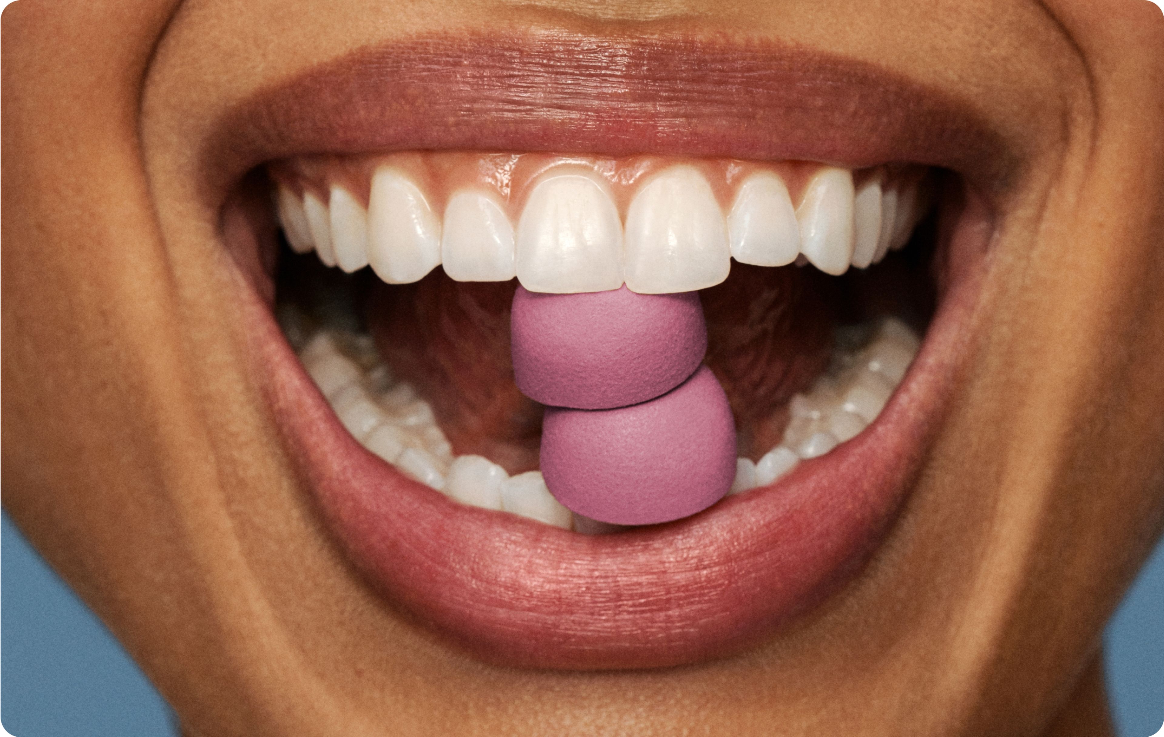 woman with two Urolithin A Gummies in her mouth