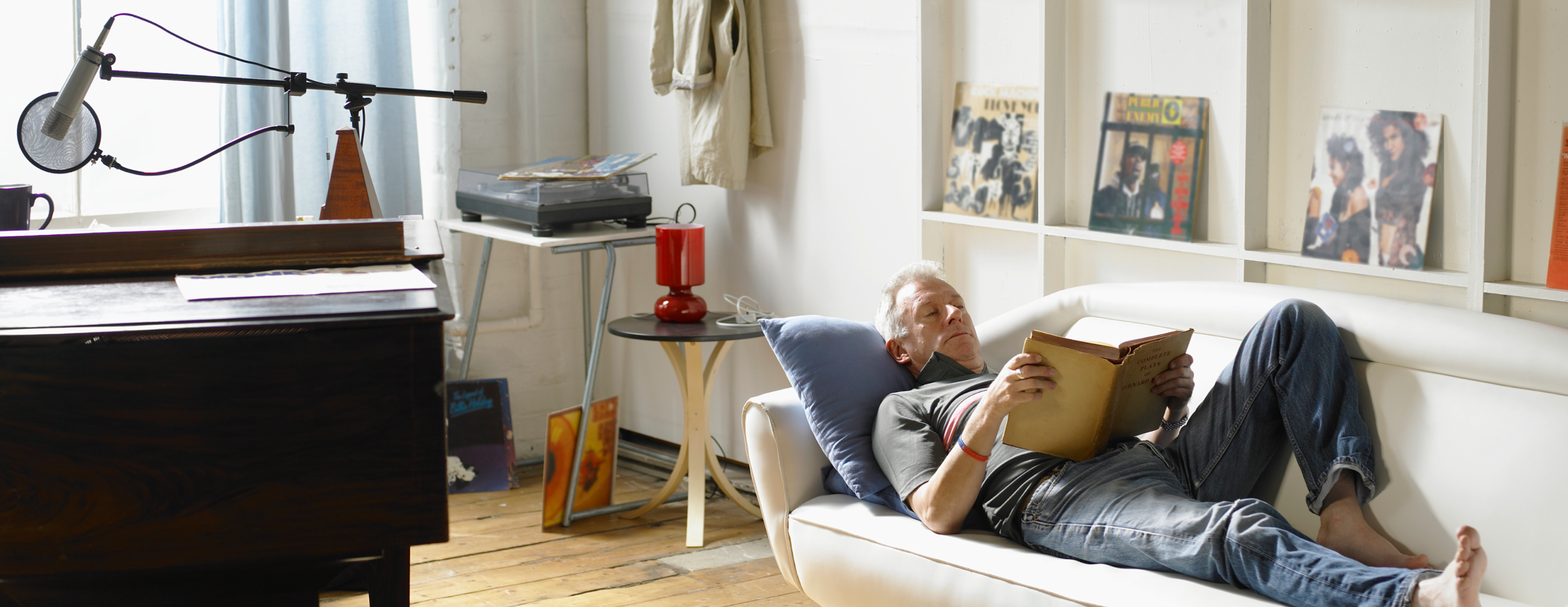 A person laying in the couch reading a book