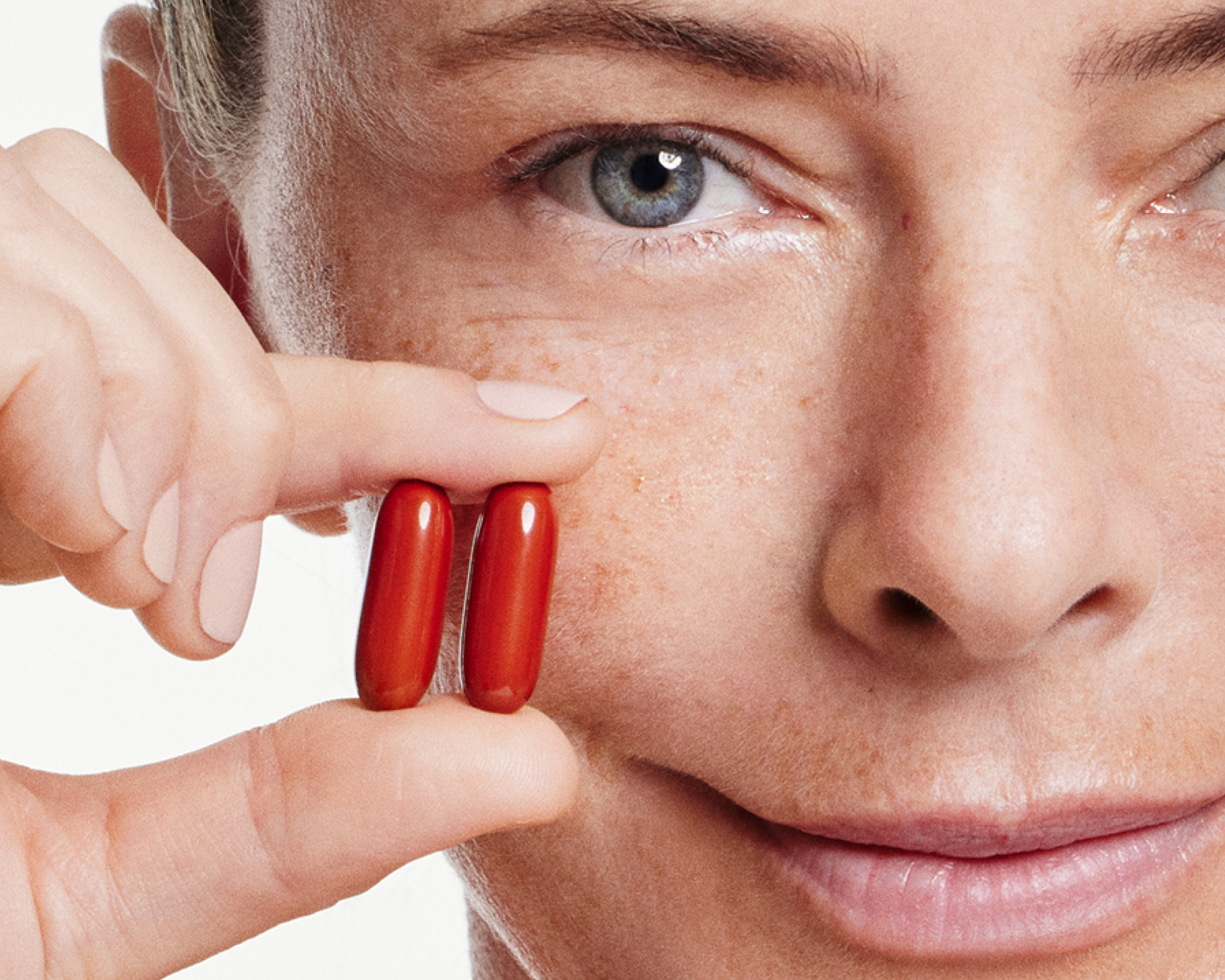 woman holding 2 mitopure softgels