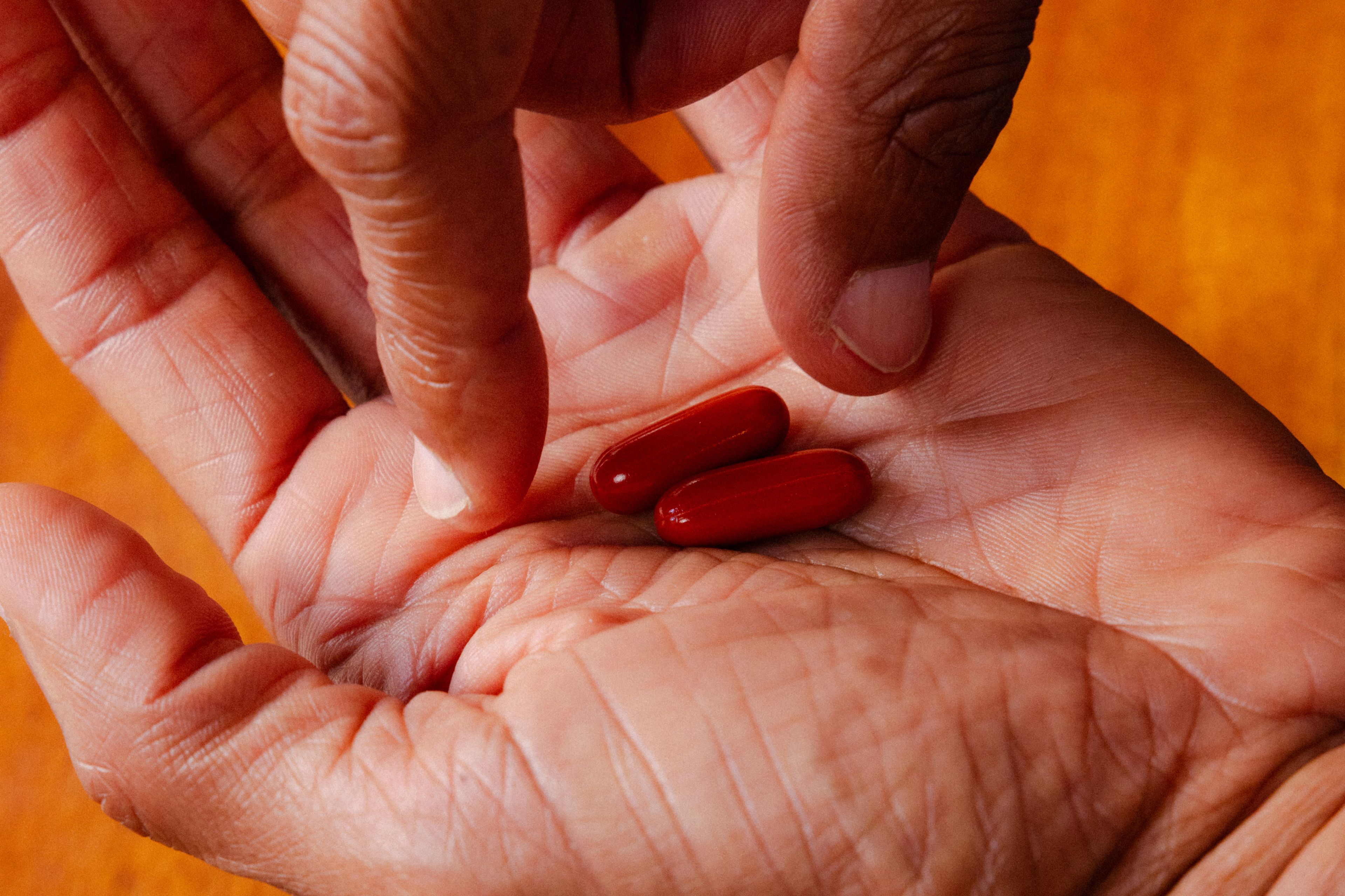 Hand with Mitopure Softgels