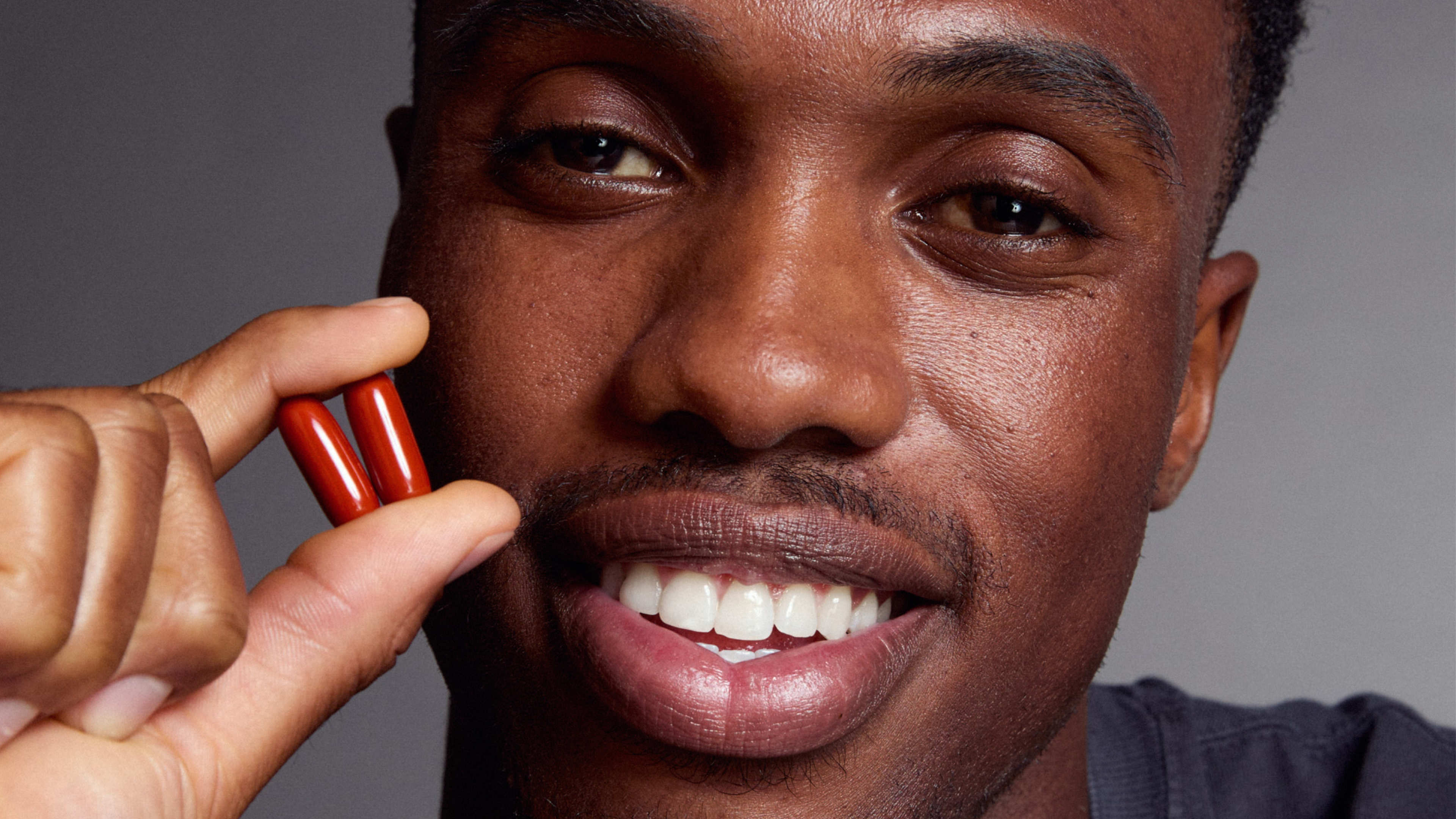 man holding two Urolithin A Softgels
