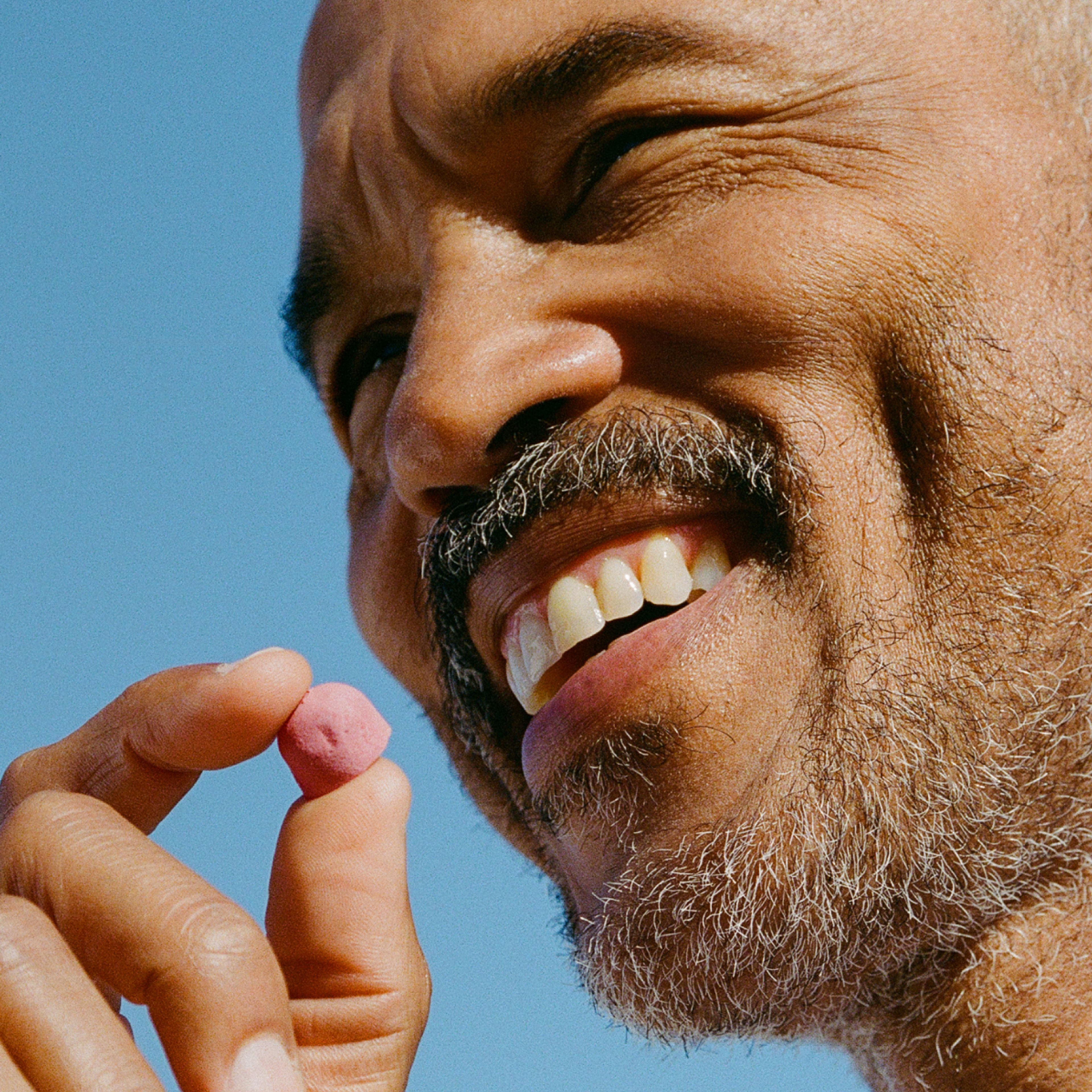 Man smiling with Urolithin A Mitopure Gummy
