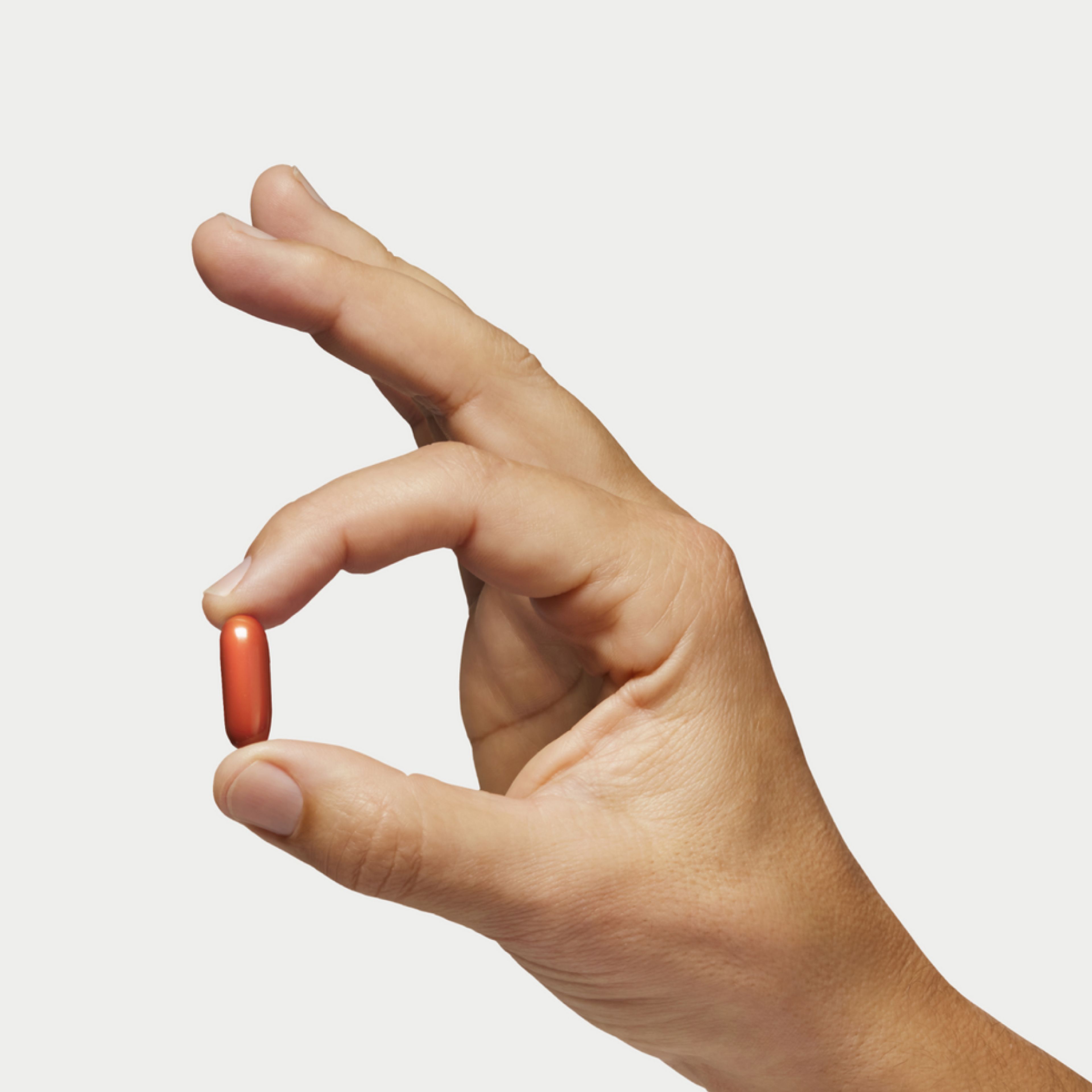 Hand holding a Mitopure Softgel pill