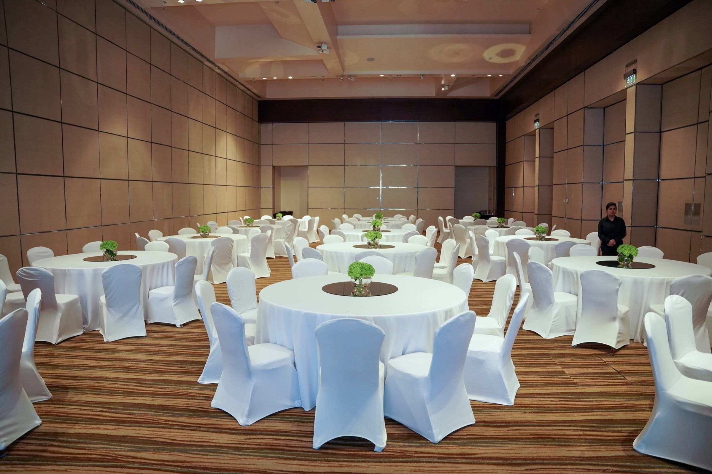 Round banquet tables with white chair covers in a hotel hall