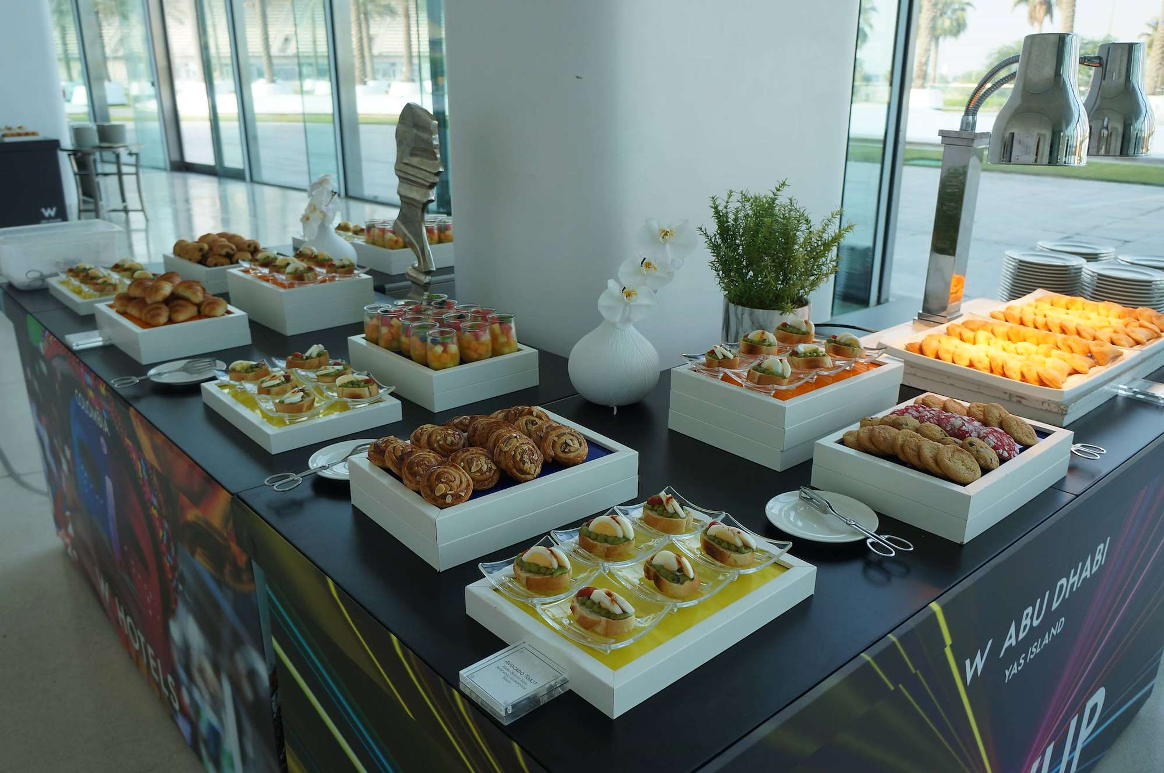 Coffee break buffet set up beside floor-to-ceiling windows at a corporate conference in Abu Dhabi