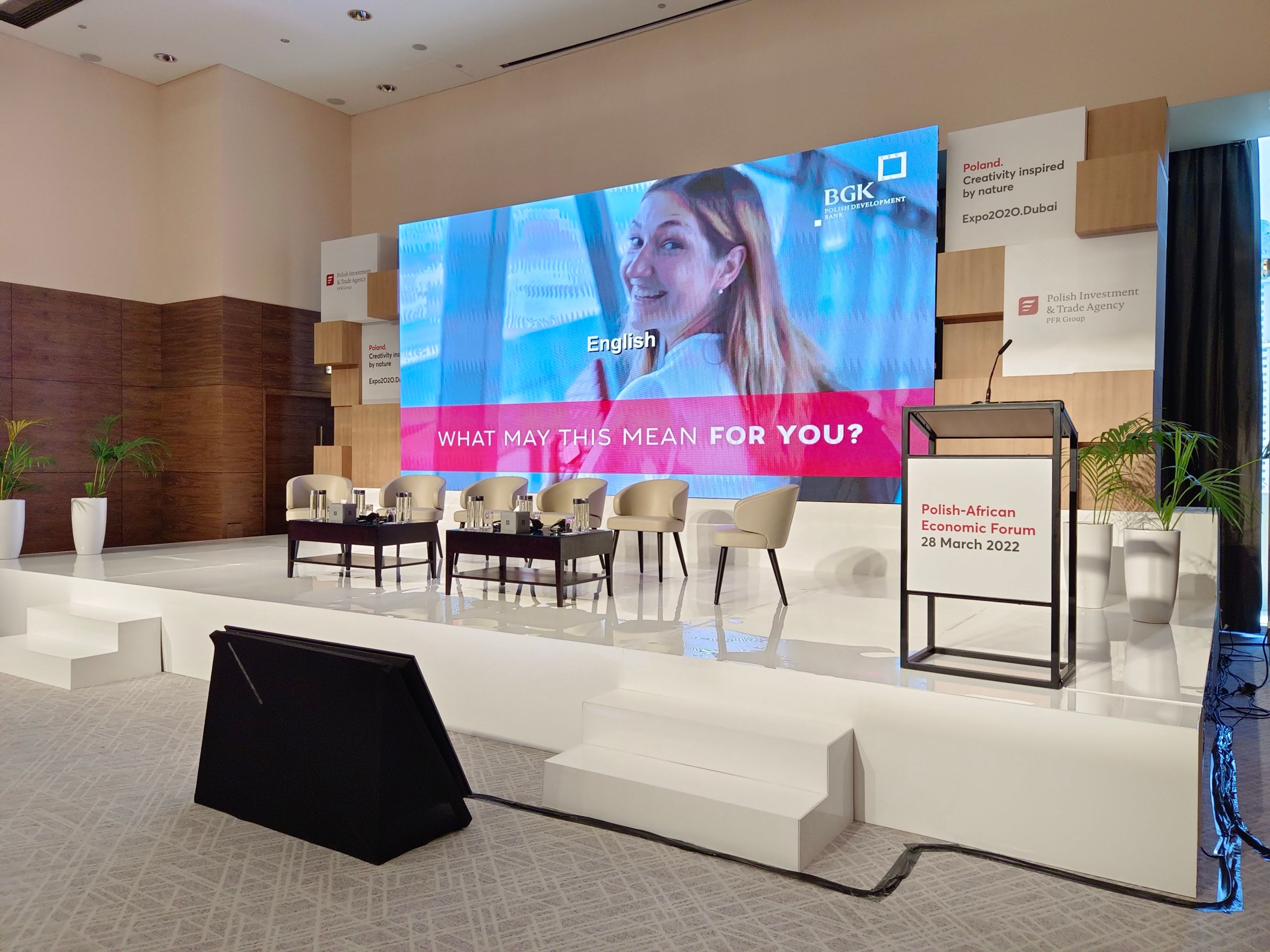 Corporate seminar with multiple projection screens and stage area.