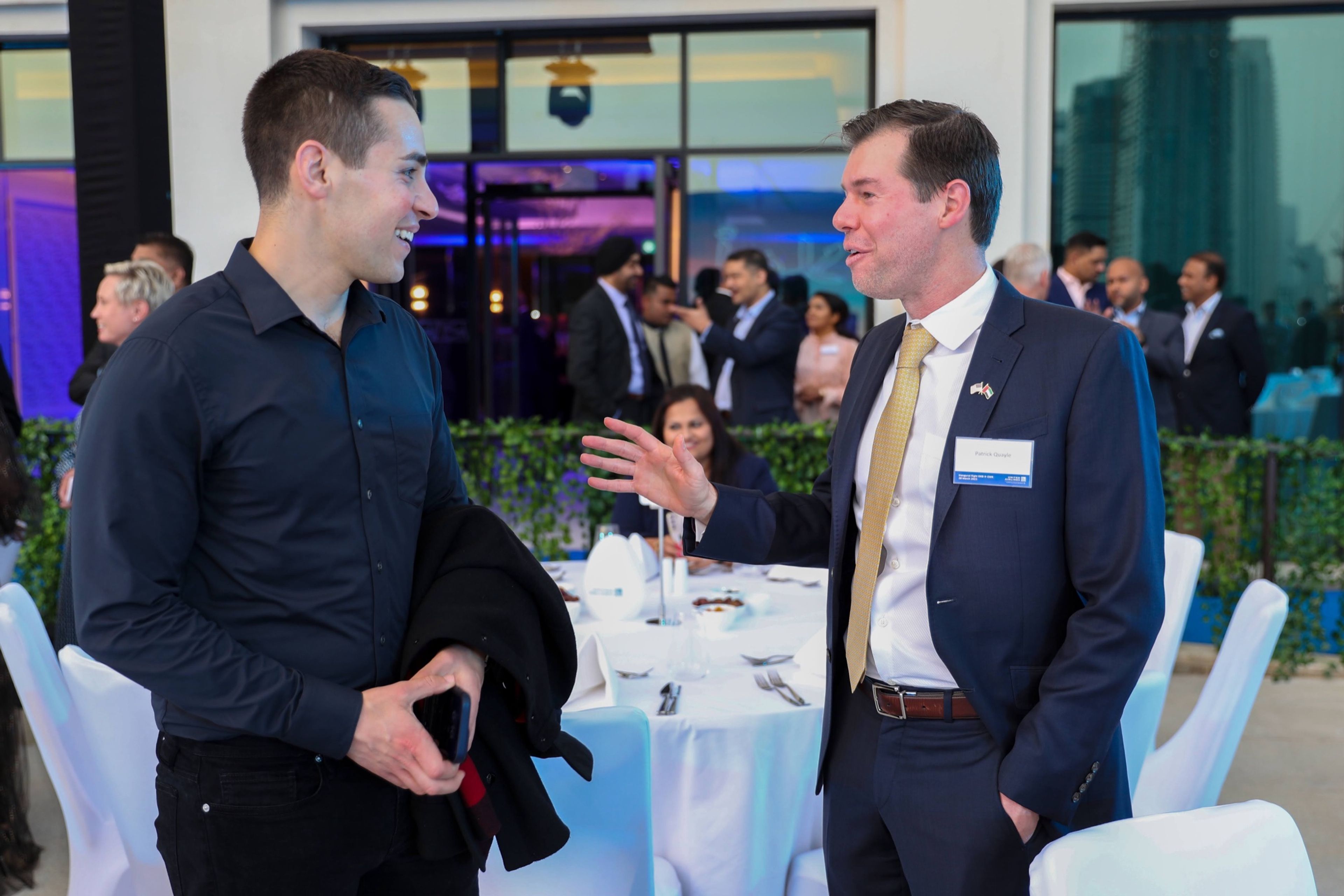 "Business professionals networking and engaging in lively conversation at a corporate gala dinner