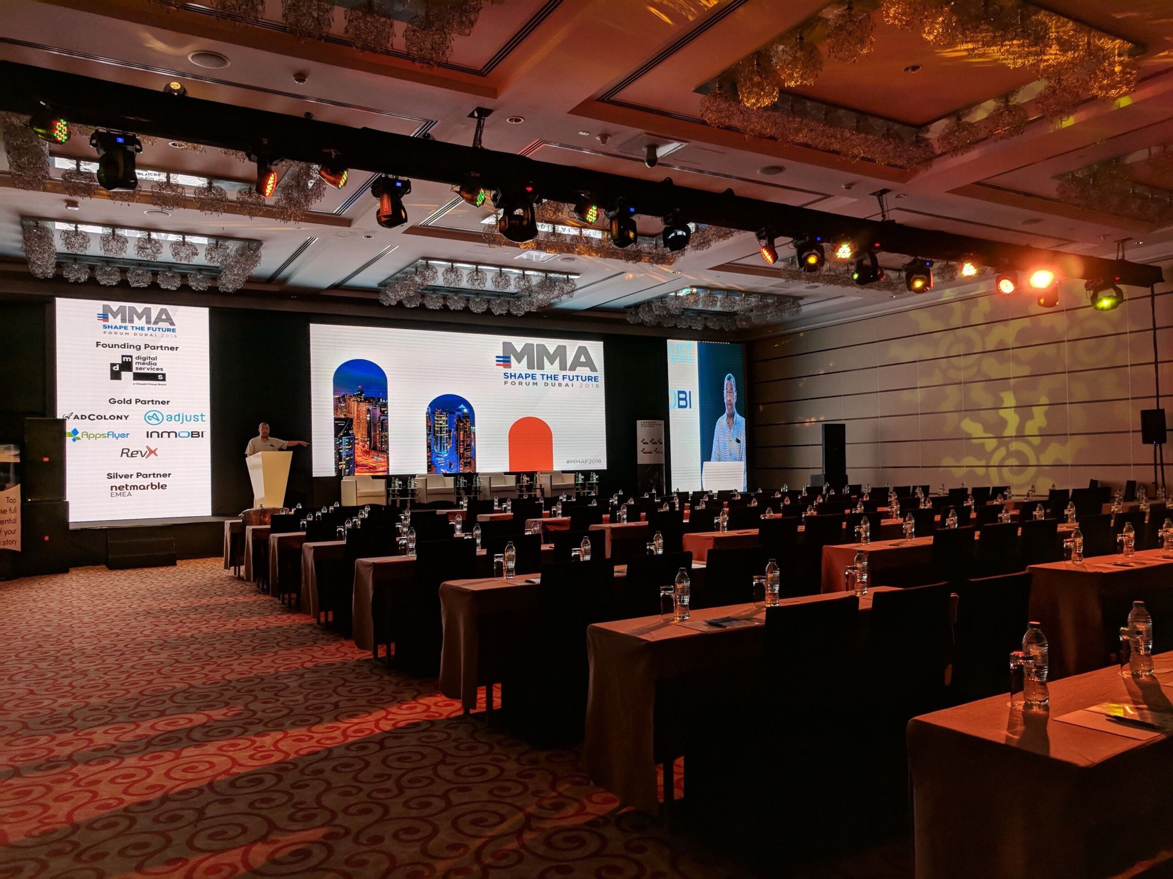 Delegates seated at a medical conference with branded stage screens