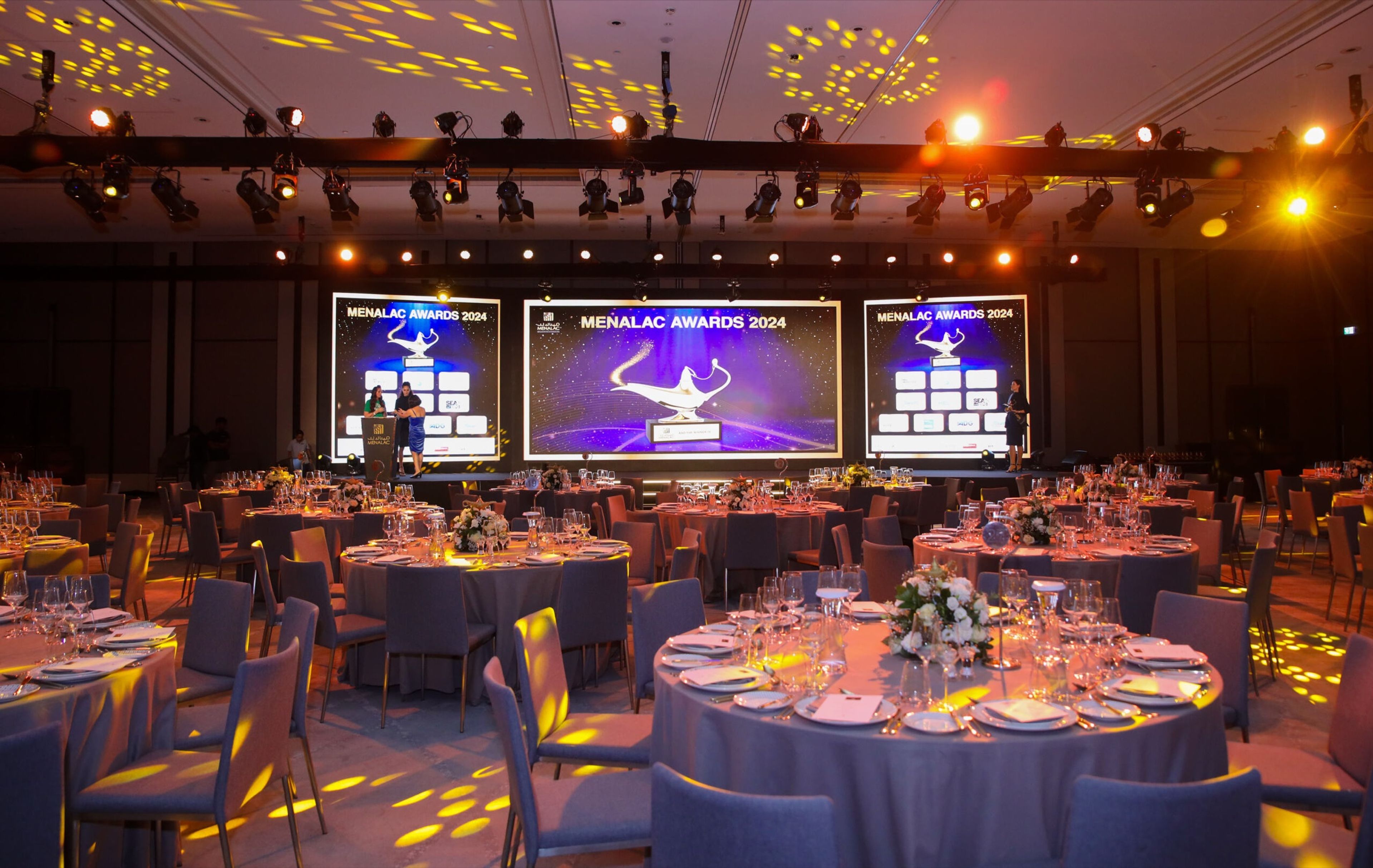 Gala dinner with three stage screens and warm lighting