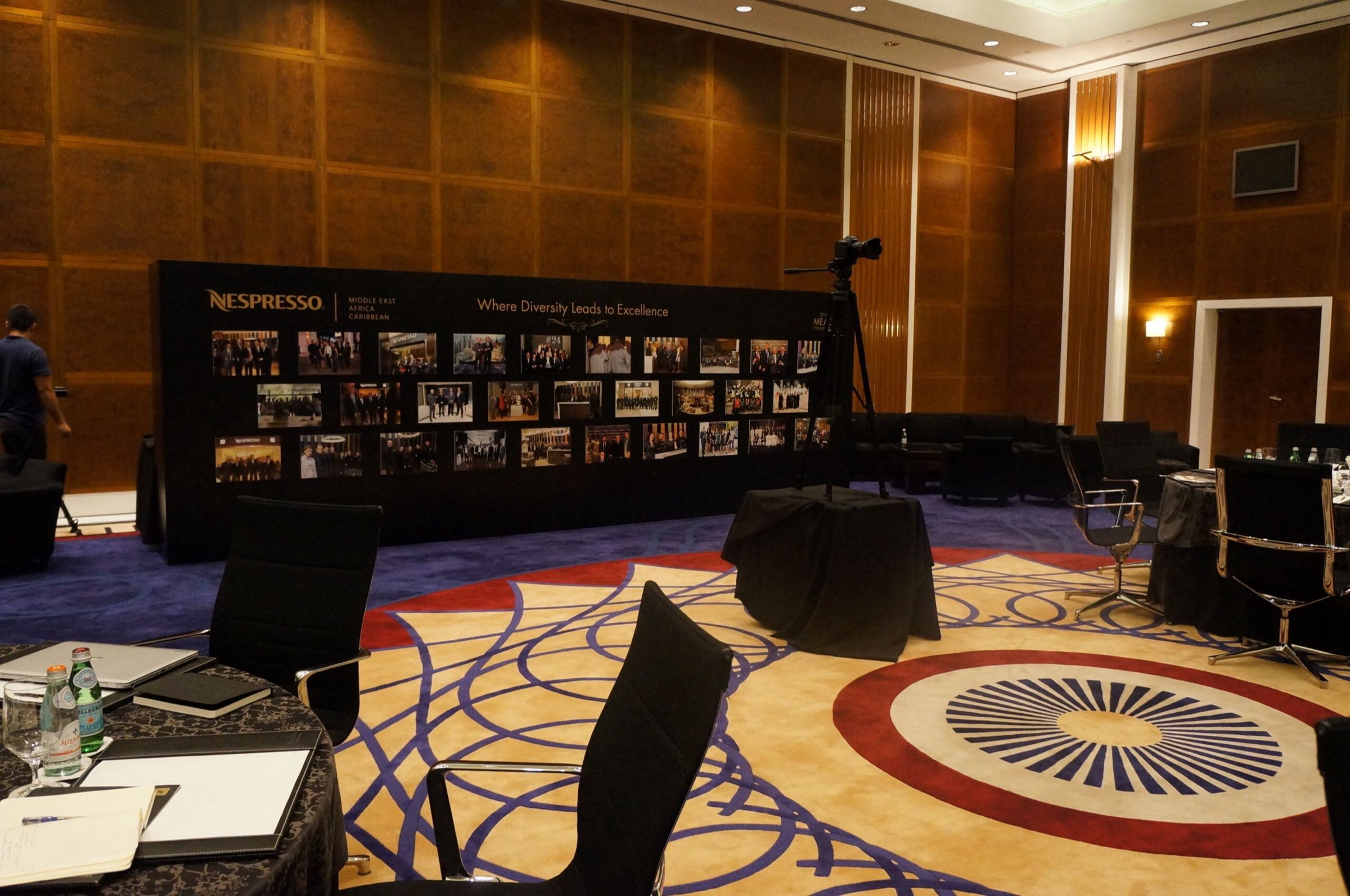 Ballroom with patterned carpet and a photo wall during event setup