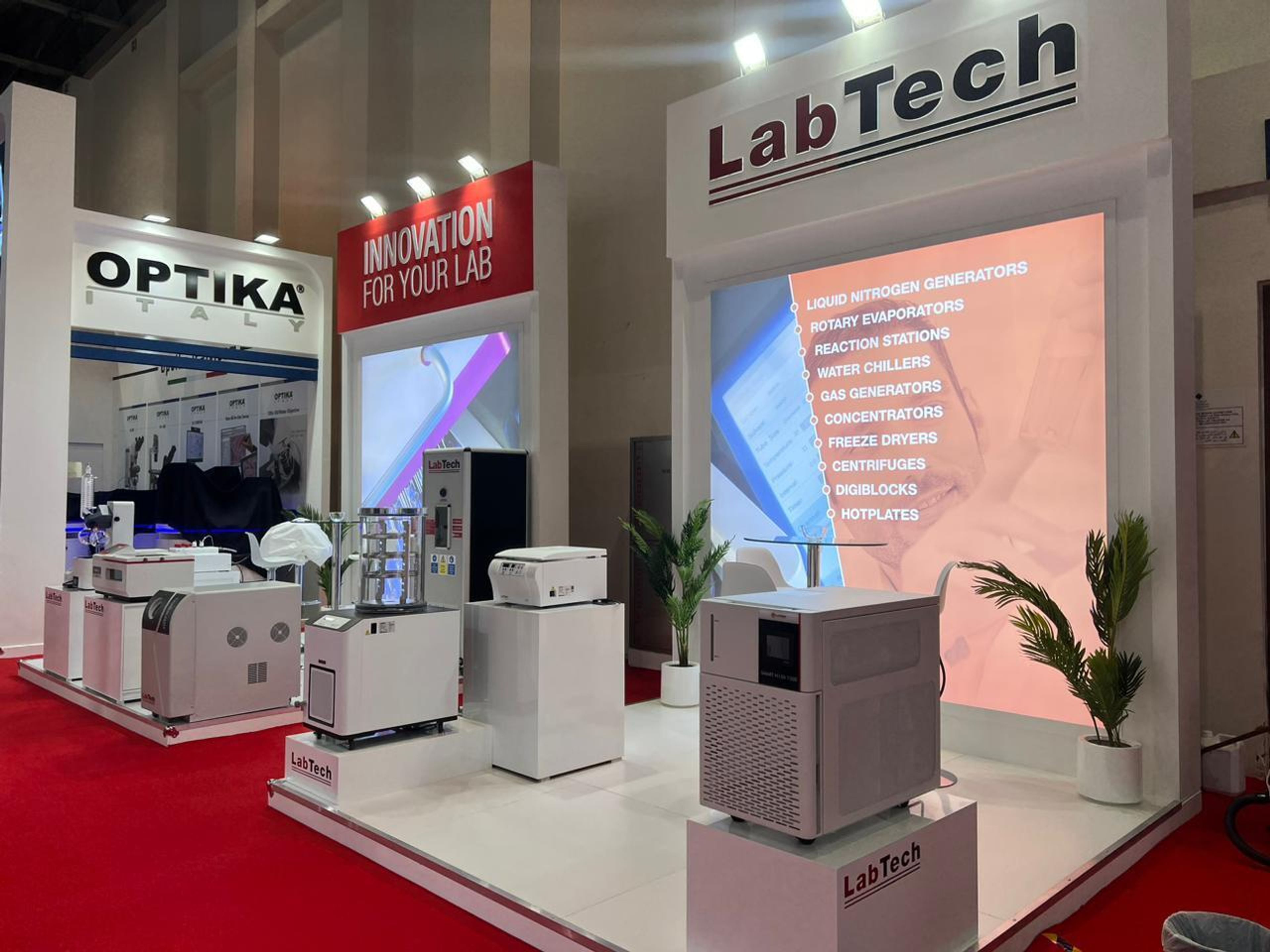 Labtech exhibition stand with lab equipment on white plinths and backlit product graphics, built by Purrple Orryx