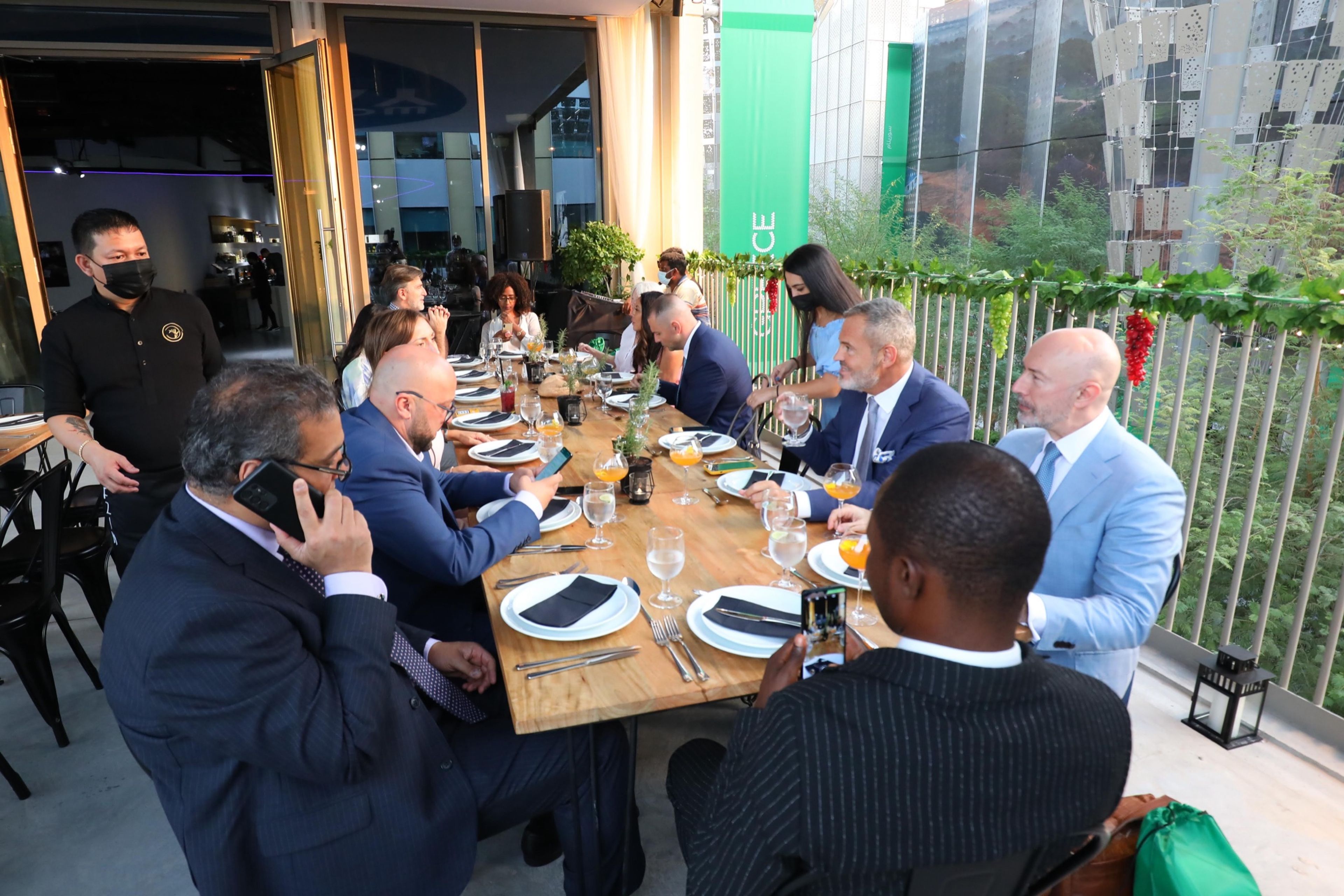Executives dining together at a long table on a terrace