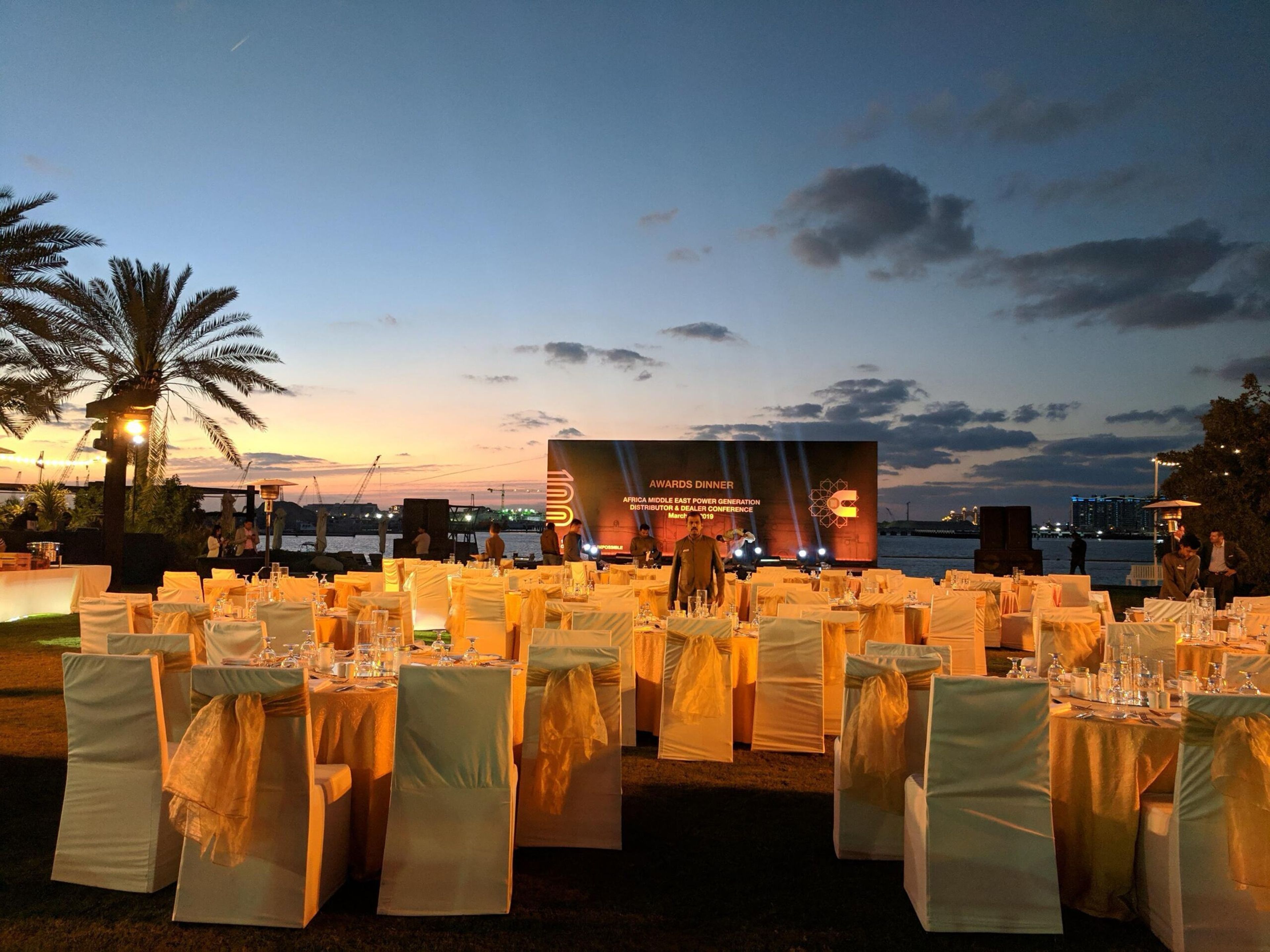 Beachfront dinner with gold-draped chairs at sunset