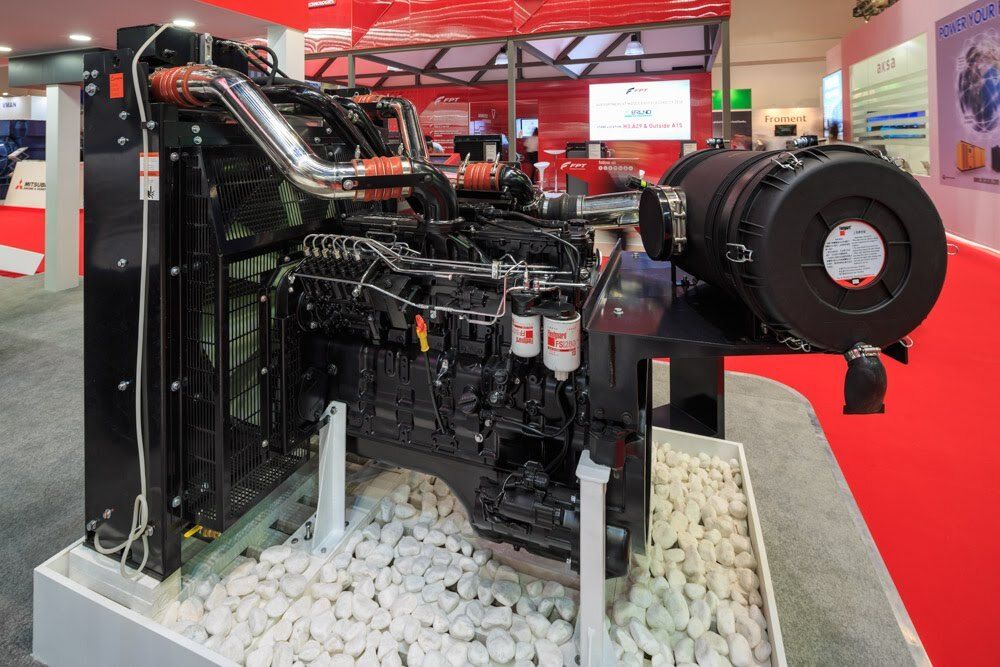 Industrial engine displayed on a red-carpeted exhibition stand