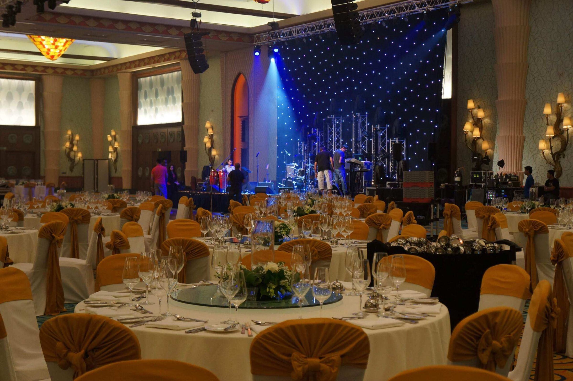 Gala dinner with round tables under blue stage lighting