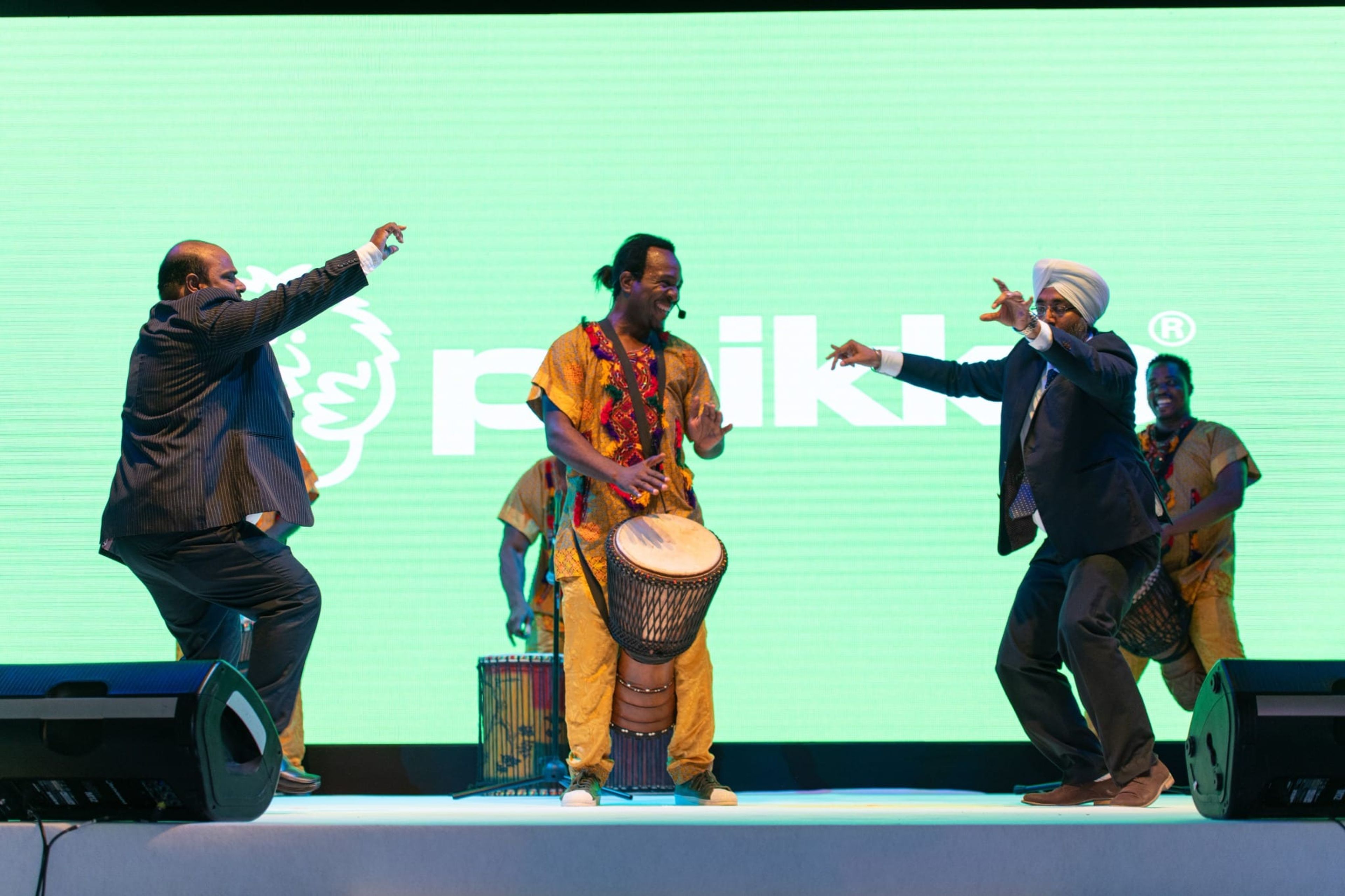 Drummers and dancers performing on stage in front of the Peikko LED screen