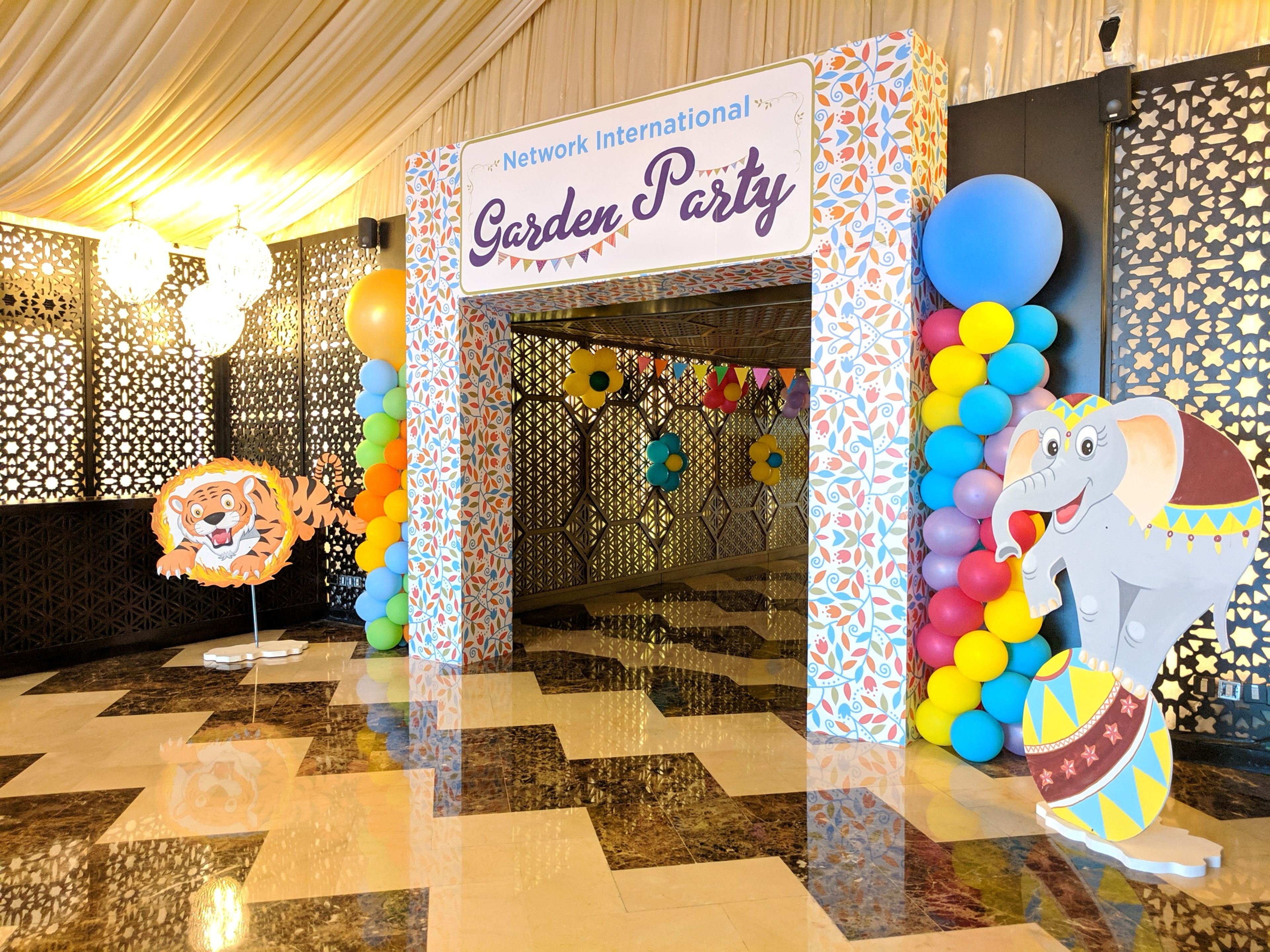 Balloon-lined entrance arch with circus animal cut-outs at an indoor corporate family day in a Dubai hotel