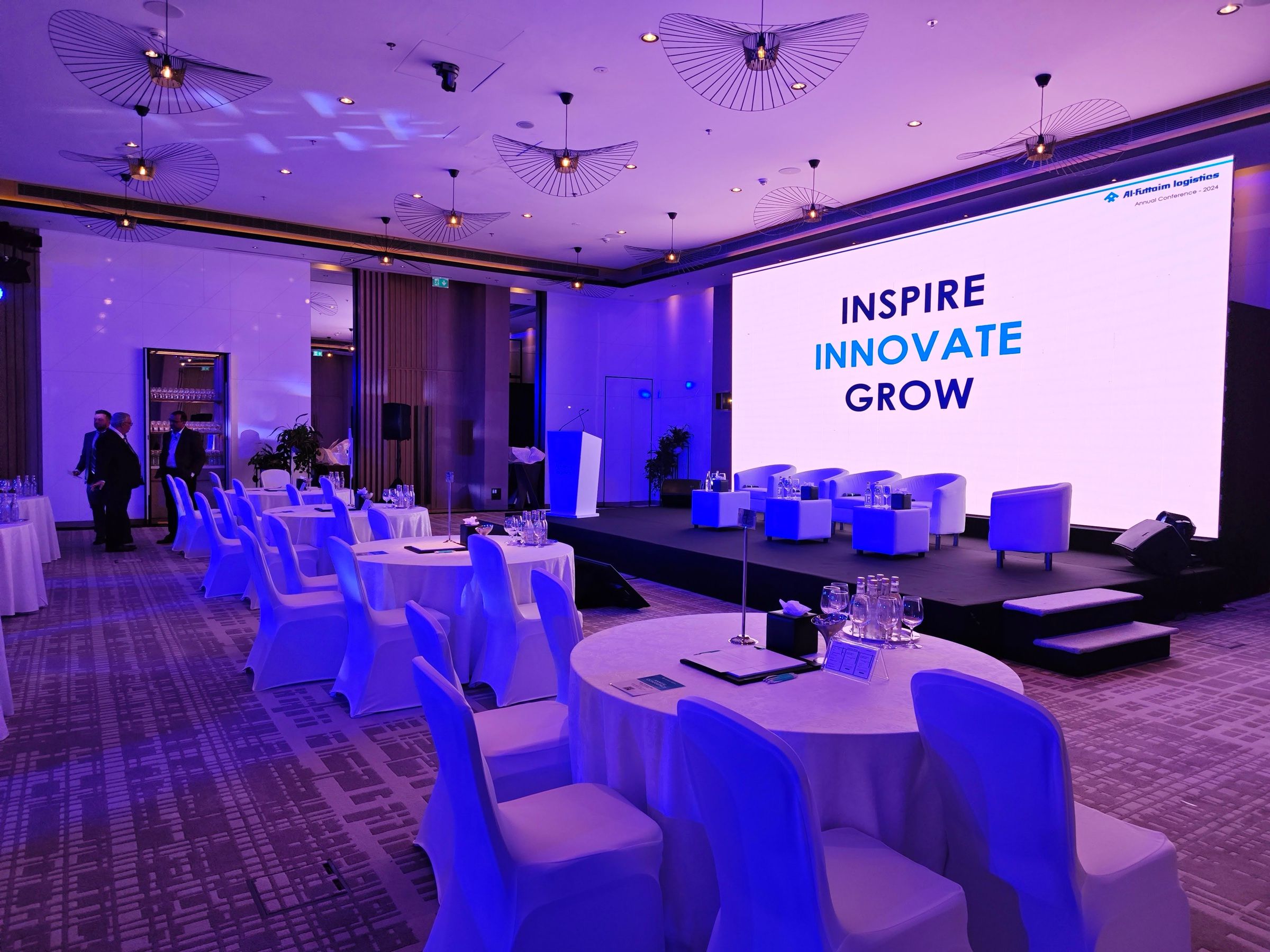 Stage with an Inspire Innovate Grow screen and purple lighting