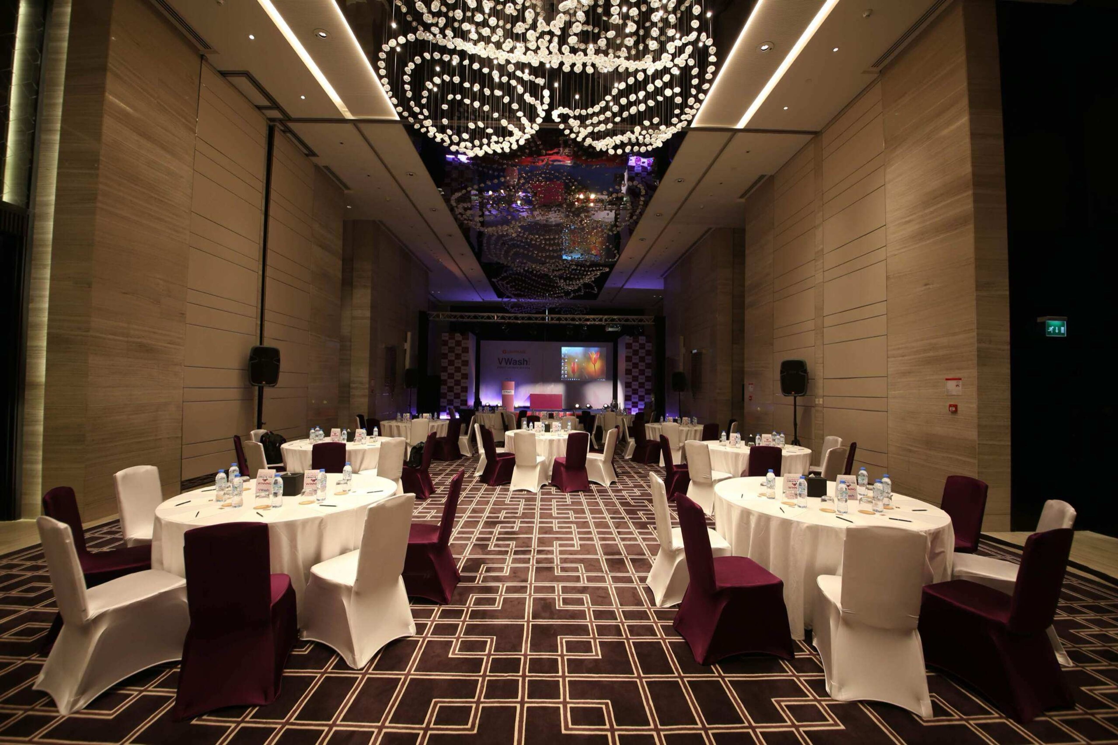 Banquet setup with white chairs and a sparkling light installation