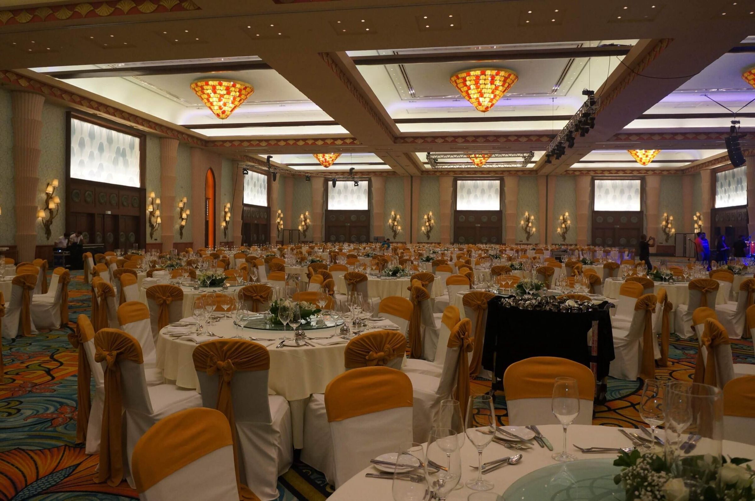 Grand ballroom set with round tables and gold chairs for a gala dinner