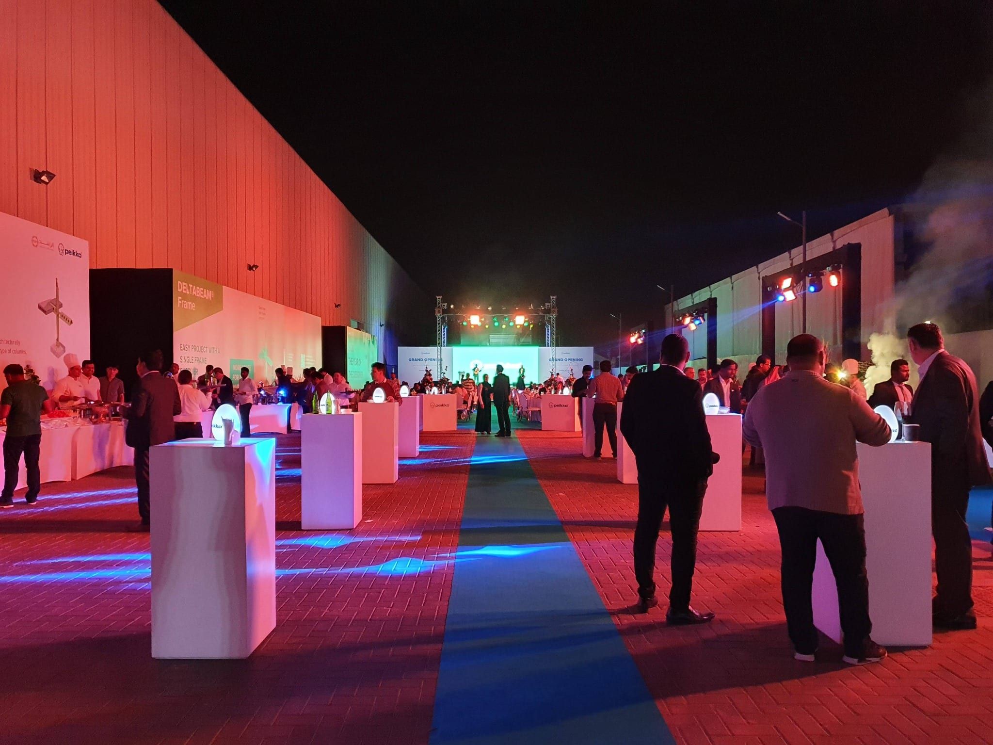 Guests at cocktail tables during the evening reception outside the Peikko facility