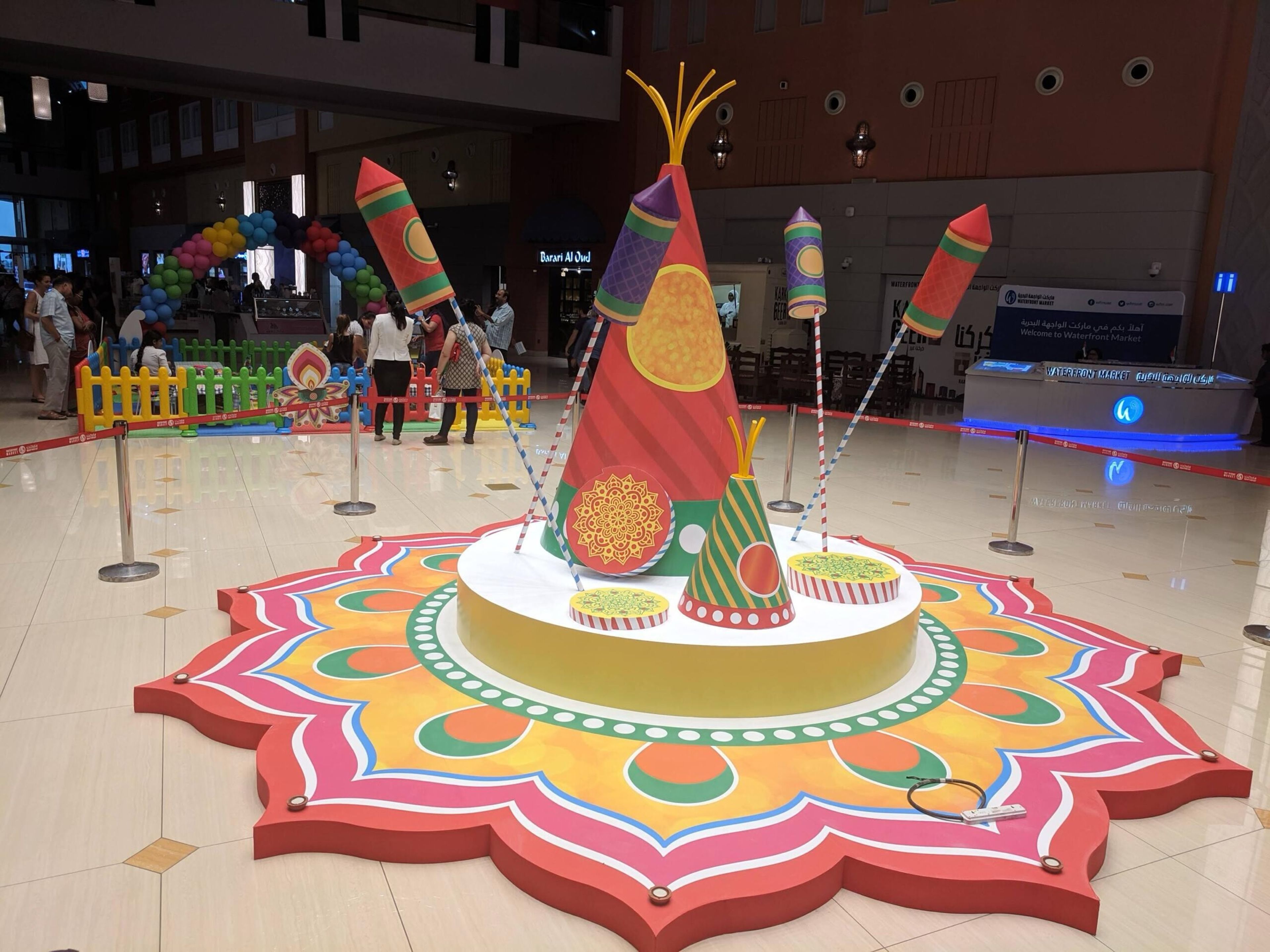 Colourful festive installation with a rangoli-style floor design