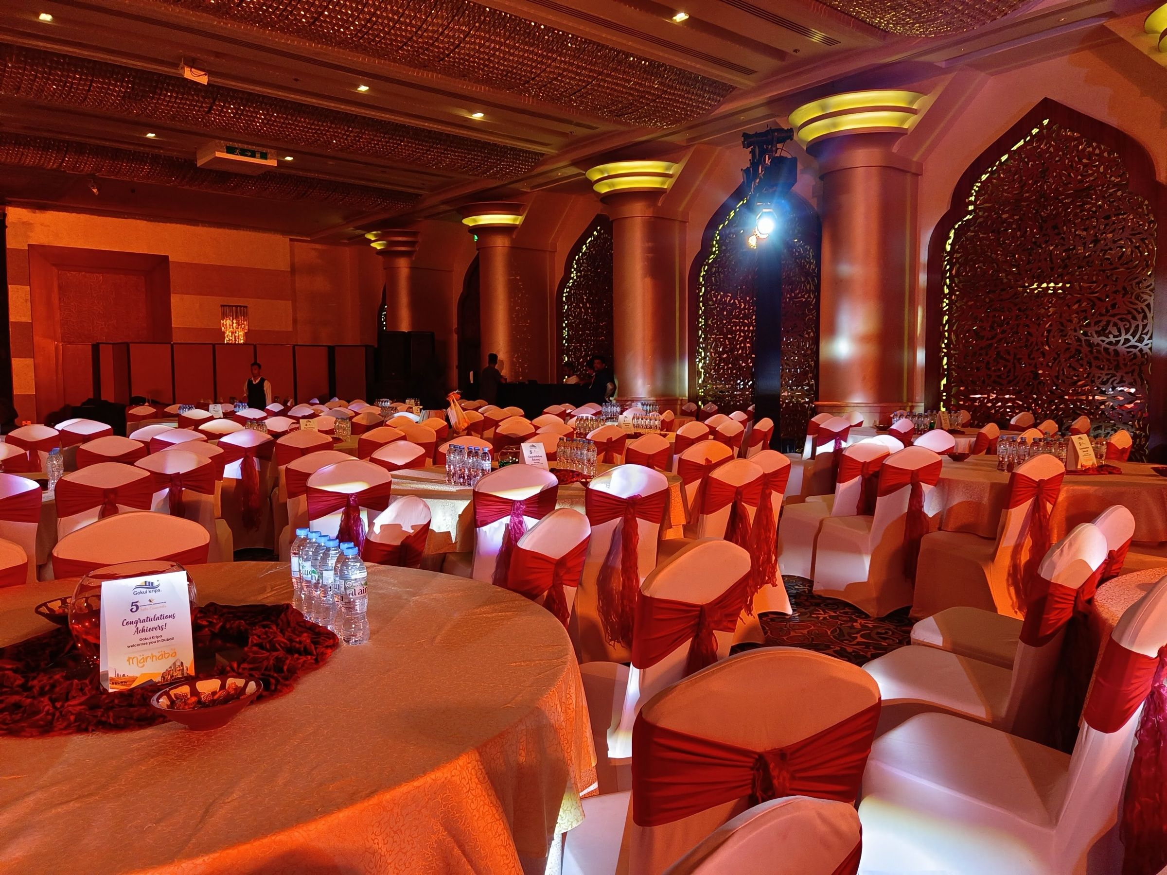 Ornate Arabian-style hall set with round tables for a gala dinner