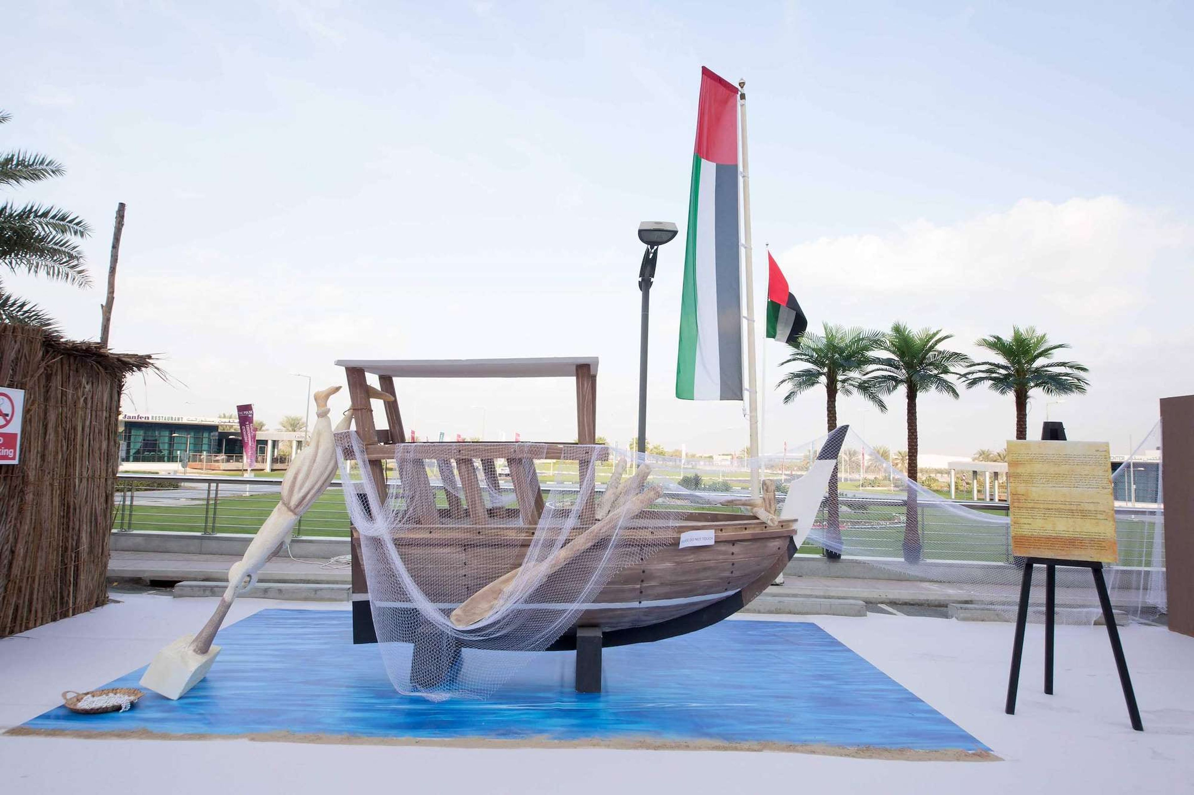 Wooden dhow and pearling scene with UAE flags at a corporate National Day celebration in Dubai