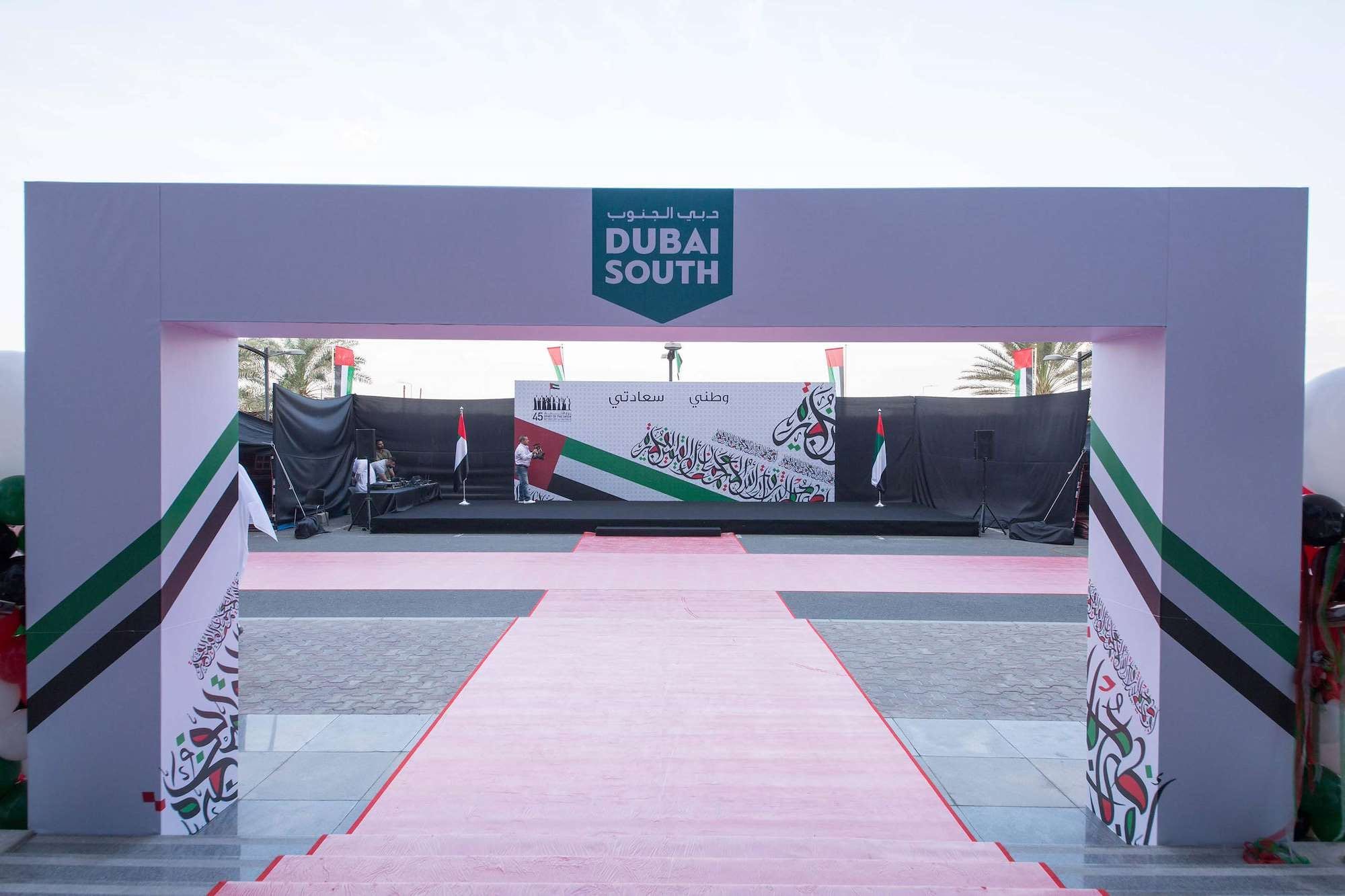 Entrance arch in UAE flag colours with a red carpet at Dubai South's headquarters