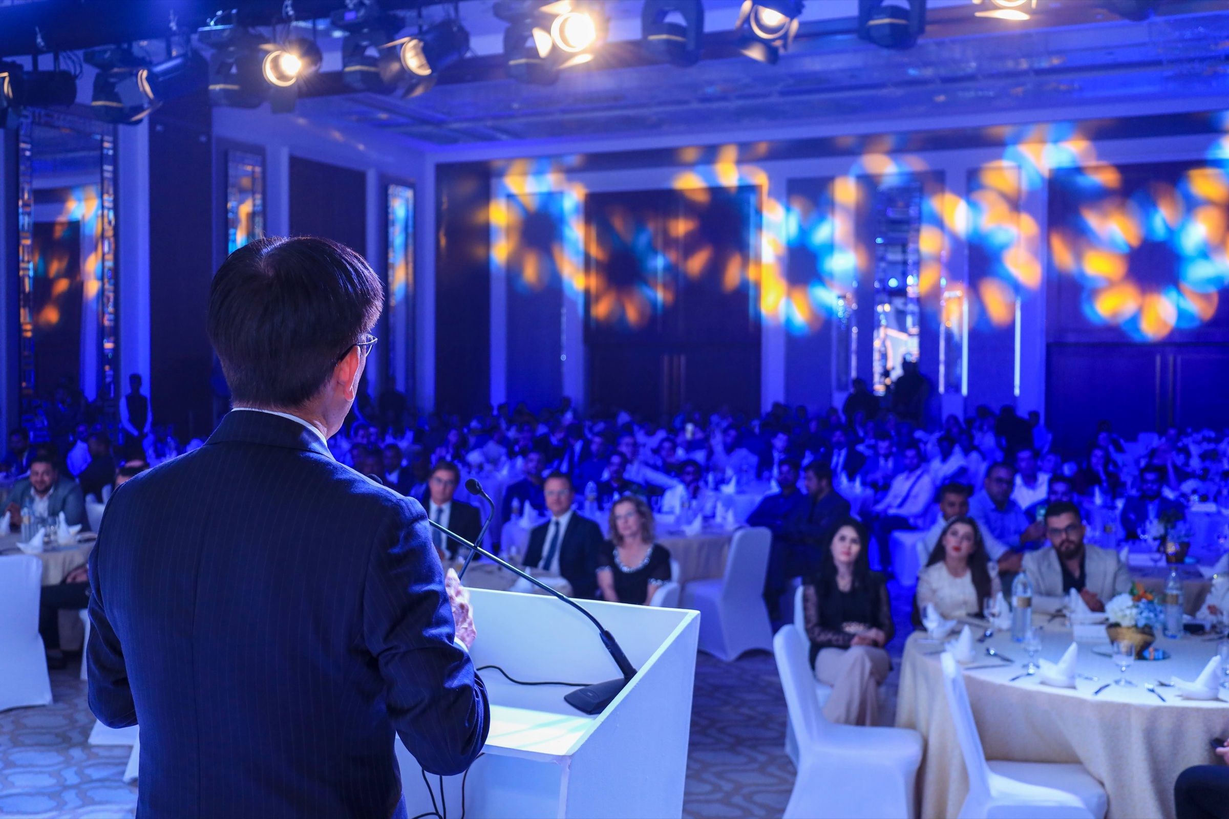 Speaker engaging with the audience at the Tokai event, with vibrant lighting and a dynamic ambiance creating a memorable atmosphere.