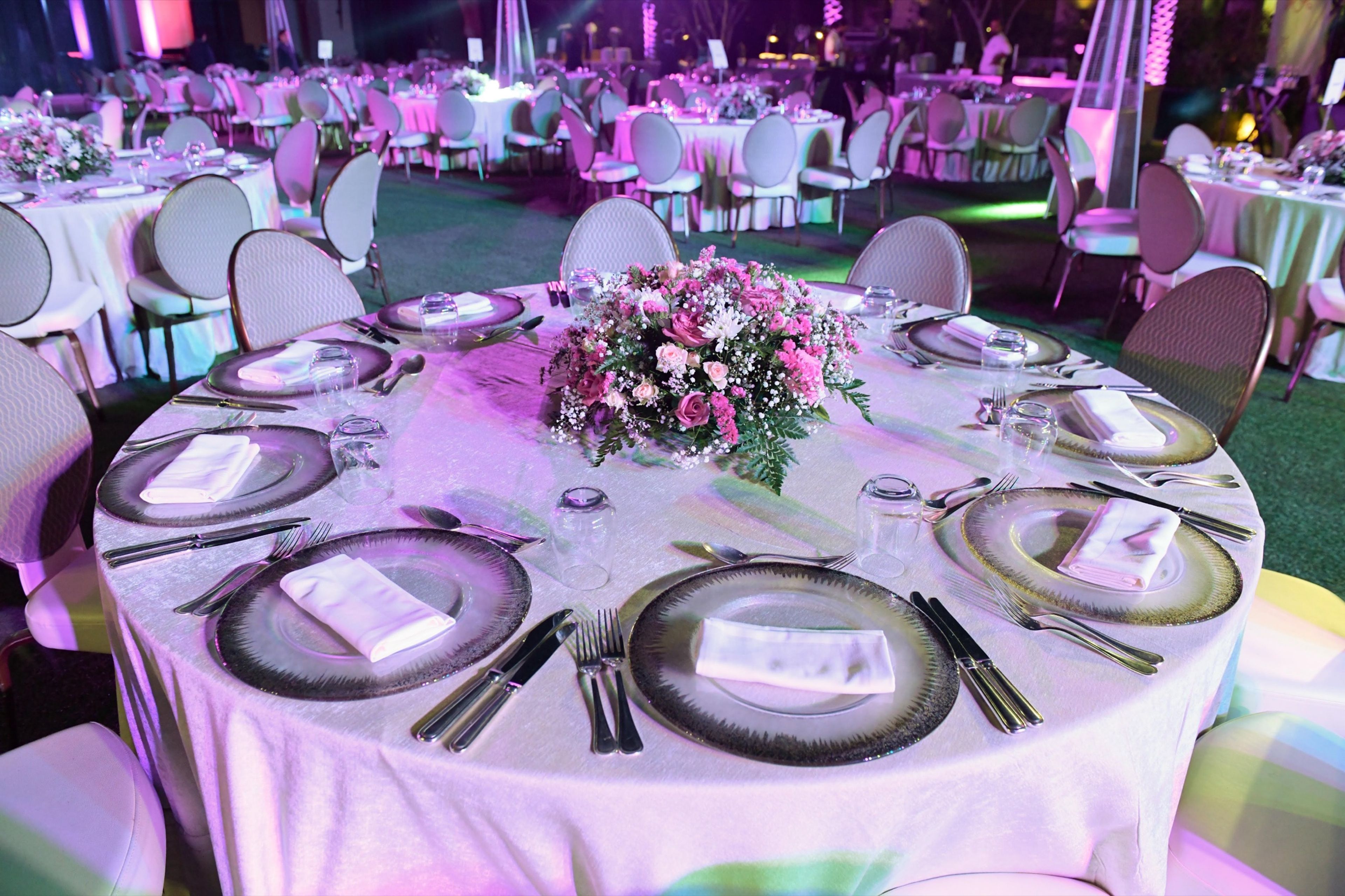 Round dinner table with pink florals and fine tableware
