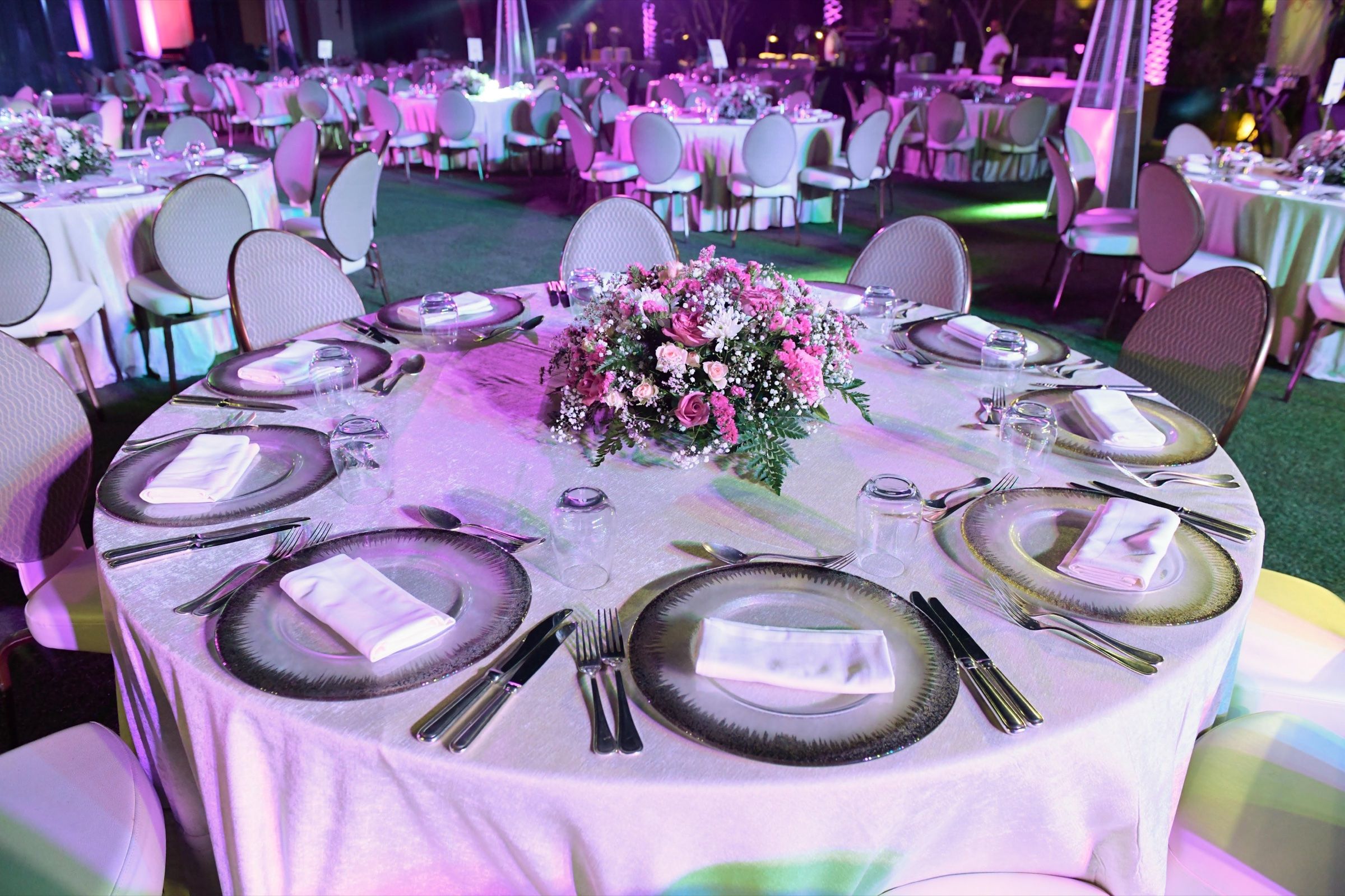Round dinner table with pink florals and fine tableware