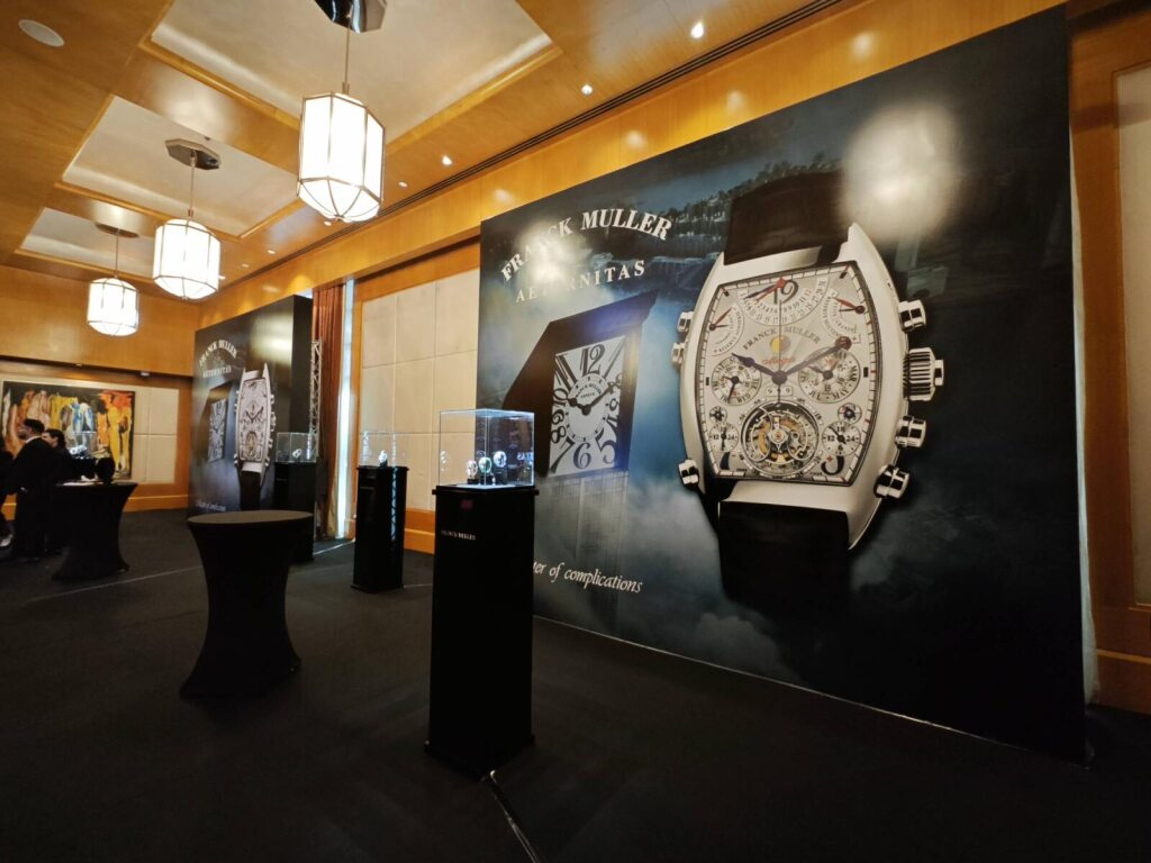 Luxury watch brand event with a large backlit watch display