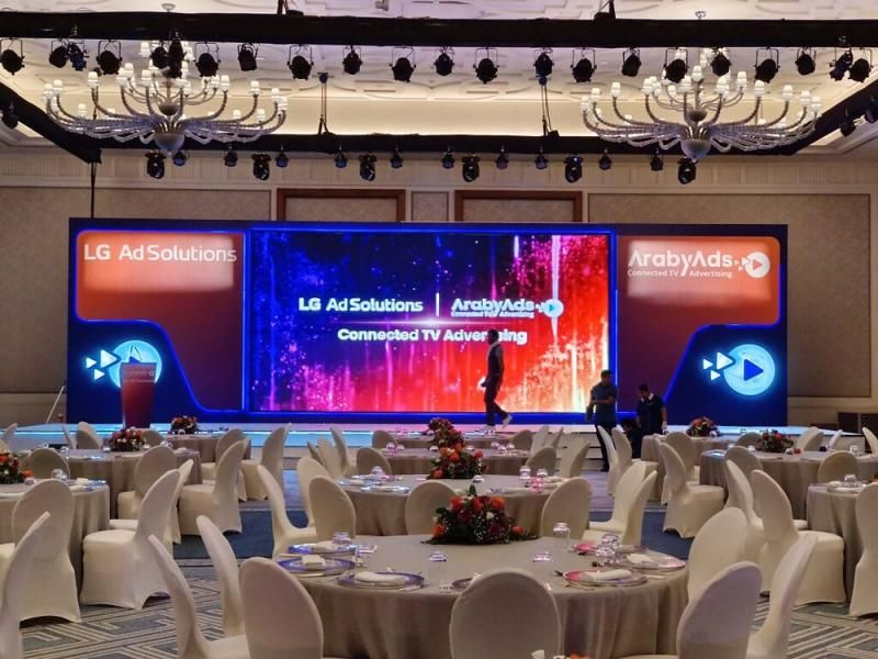 Brand launch event with a wide LED stage screen and banquet seating