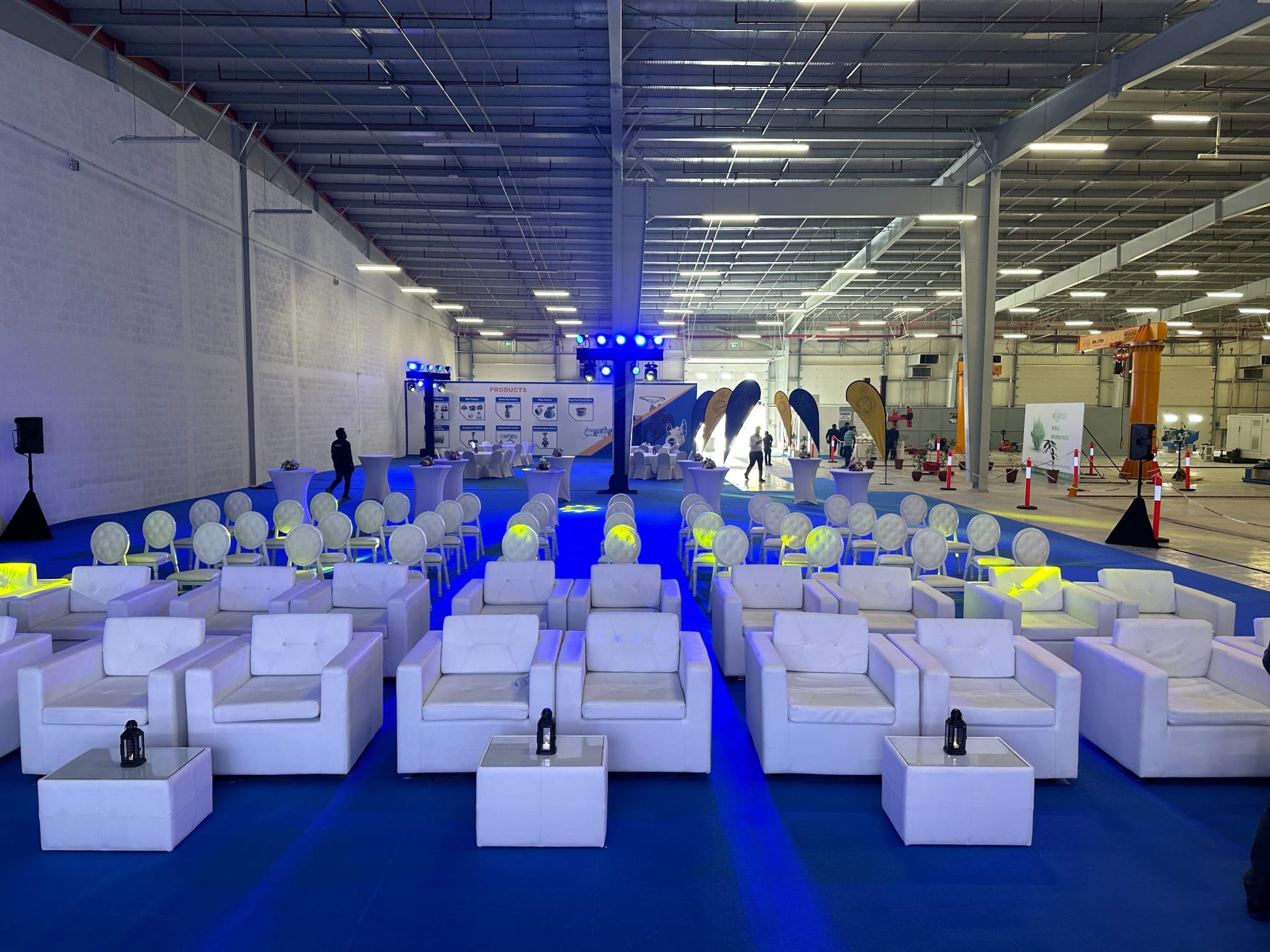 White lounge sofas and blue uplighting in the factory hall before the MT Group launch