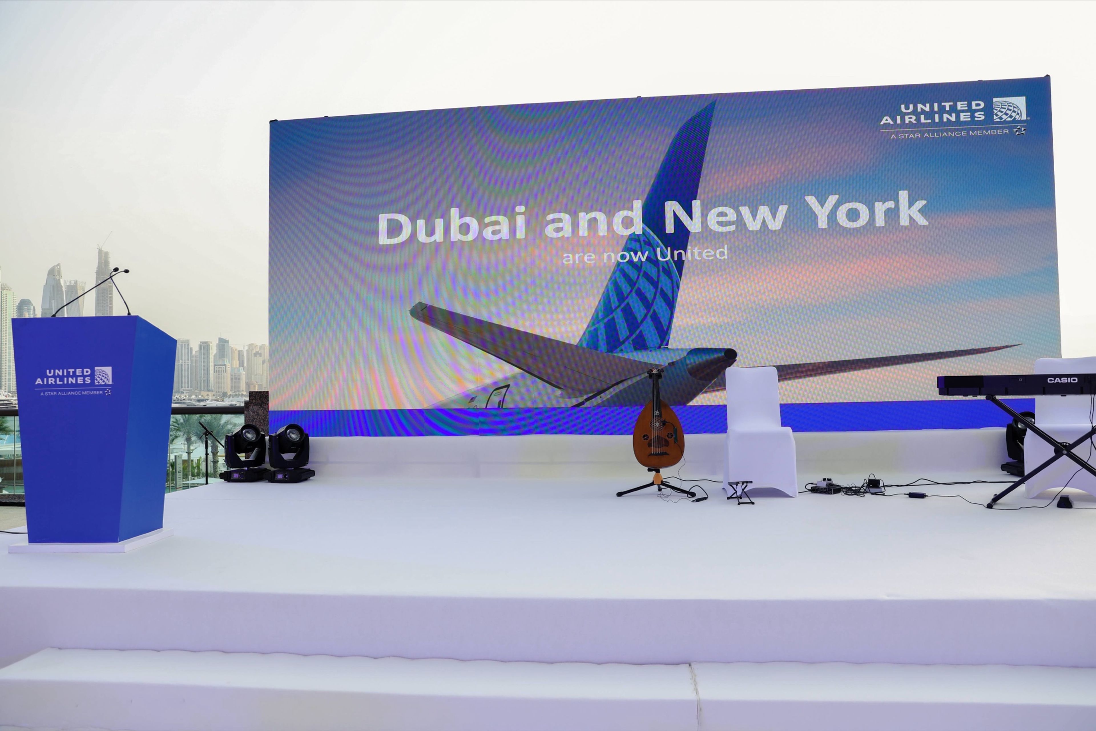 Stage setup for a professional conference, with a large screen displaying event branding