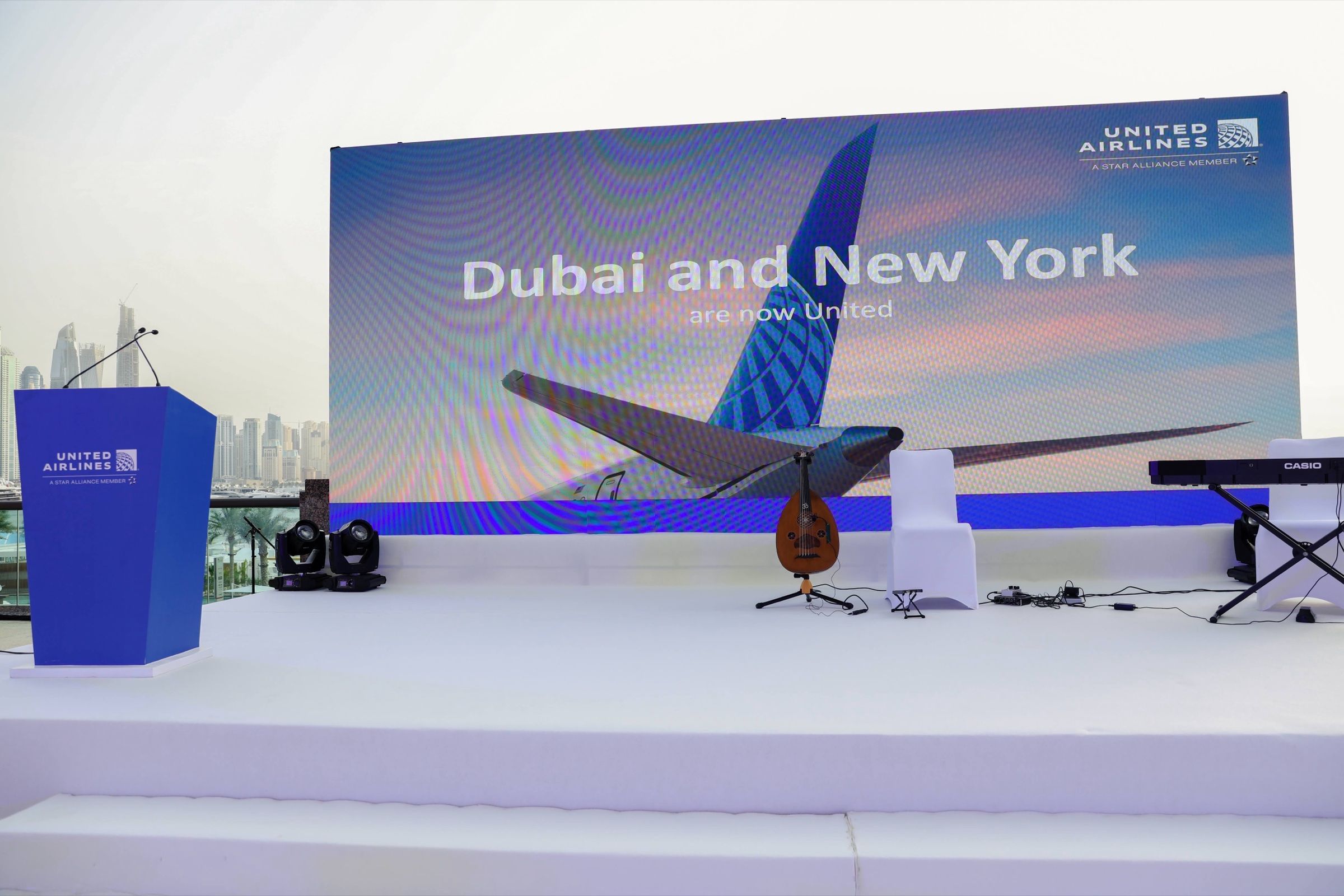 Stage setup for a professional conference, with a large screen displaying event branding