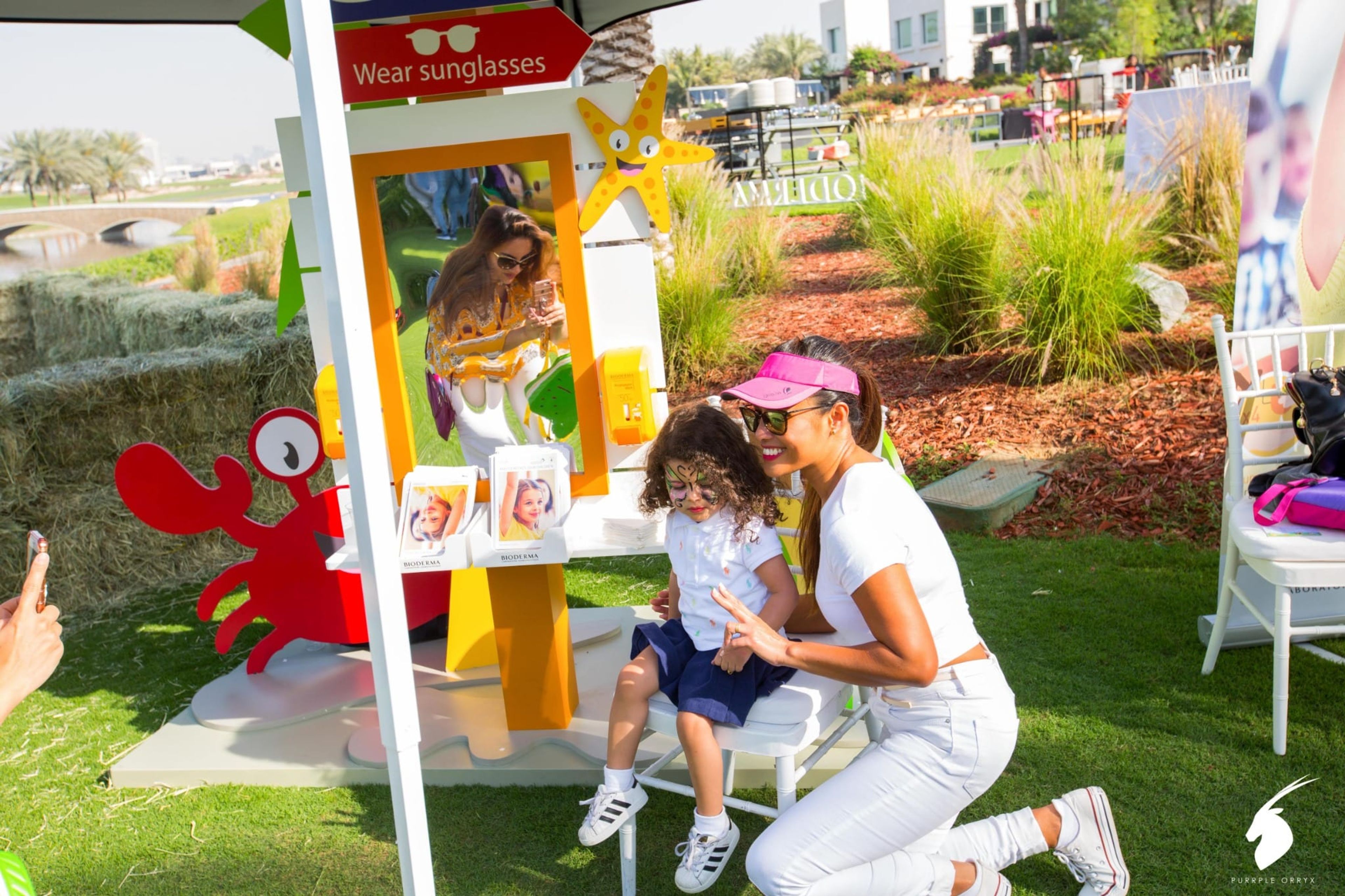 Mother and child at a sunglasses-themed photo booth