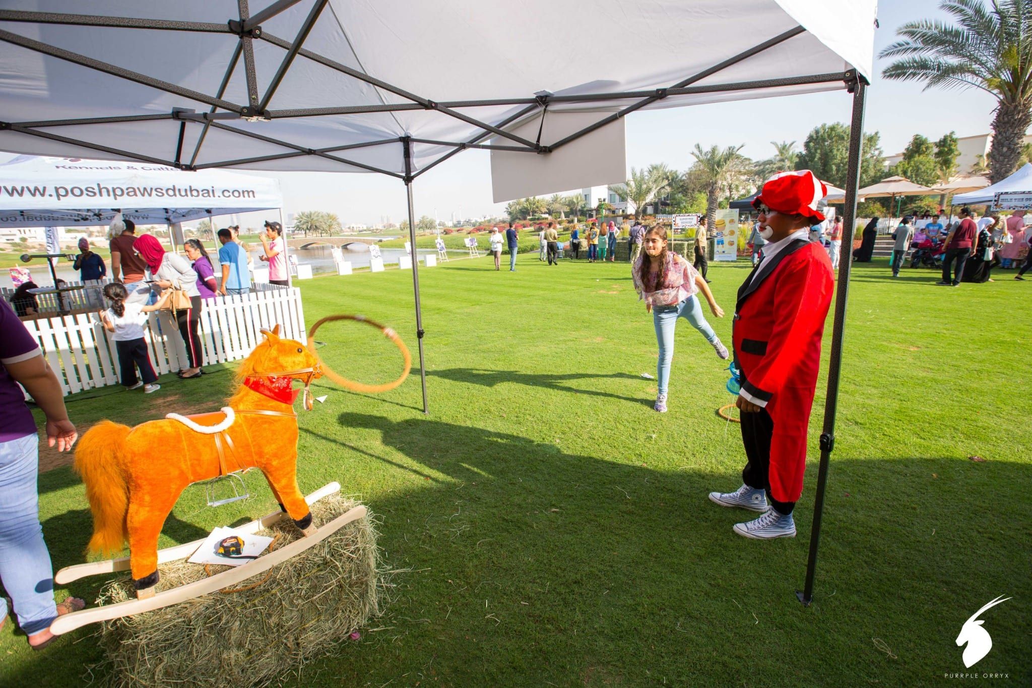 Ring toss game with a ringmaster host and a wooden horse on hay bales